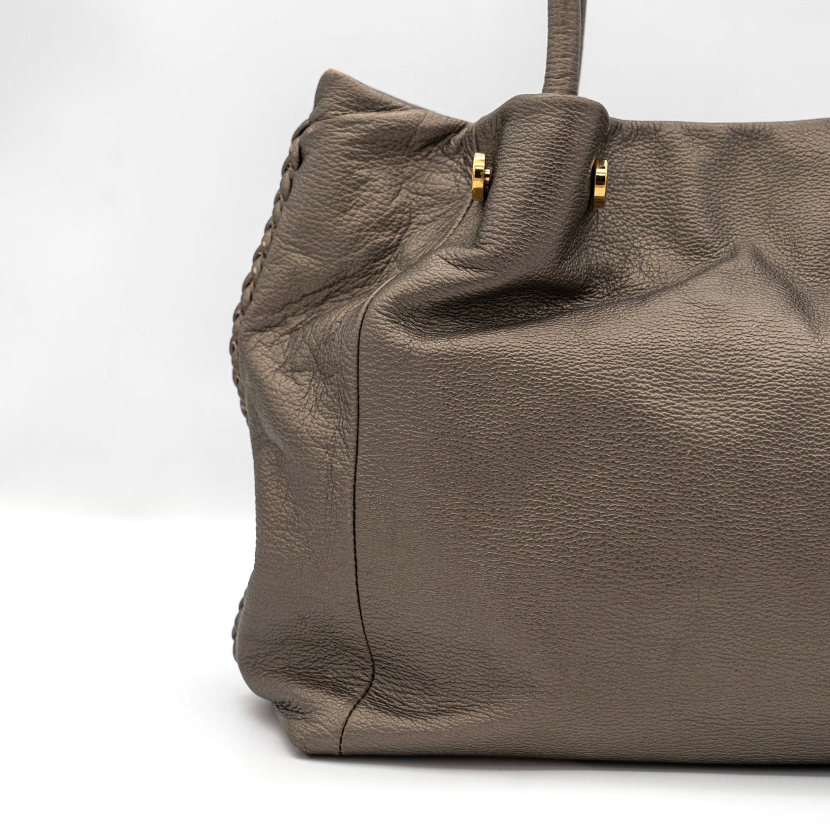 Furla taupe leather shoulder bag with gold hardware and braided detailing, photographed against a white background.