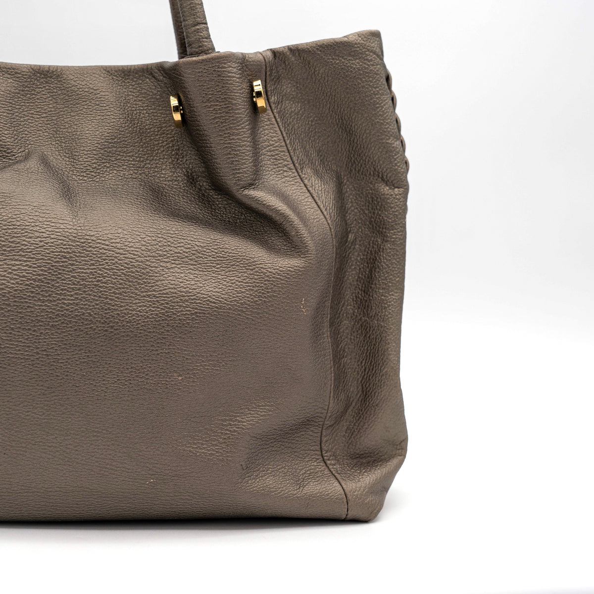 Furla taupe leather shoulder bag with gold hardware and braided detailing, photographed against a white background.