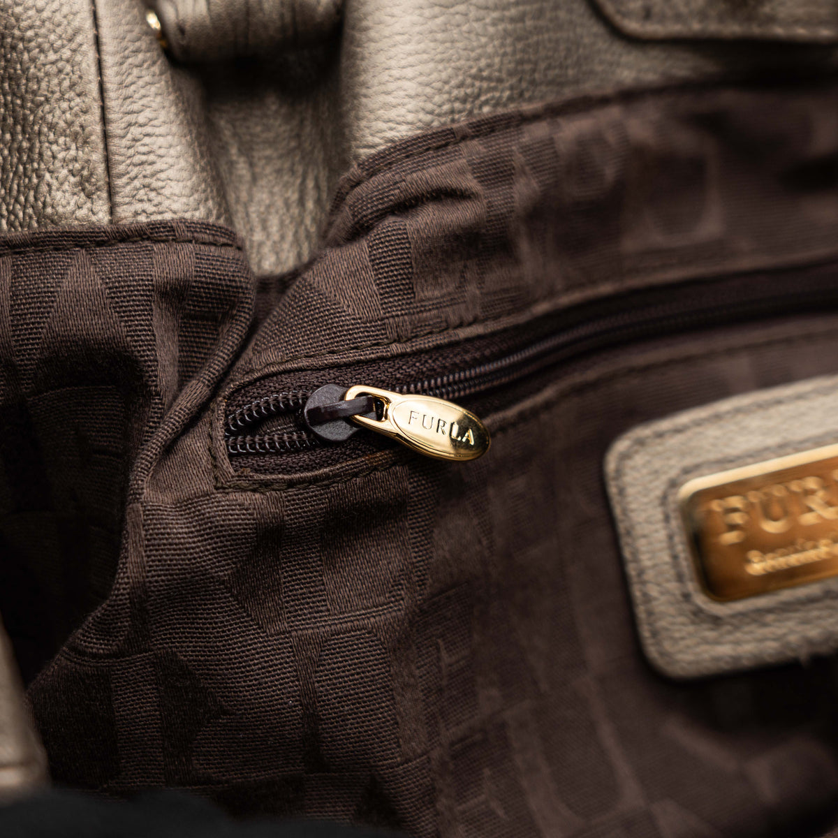 Furla taupe leather shoulder bag with gold hardware and braided detailing, photographed against a white background.