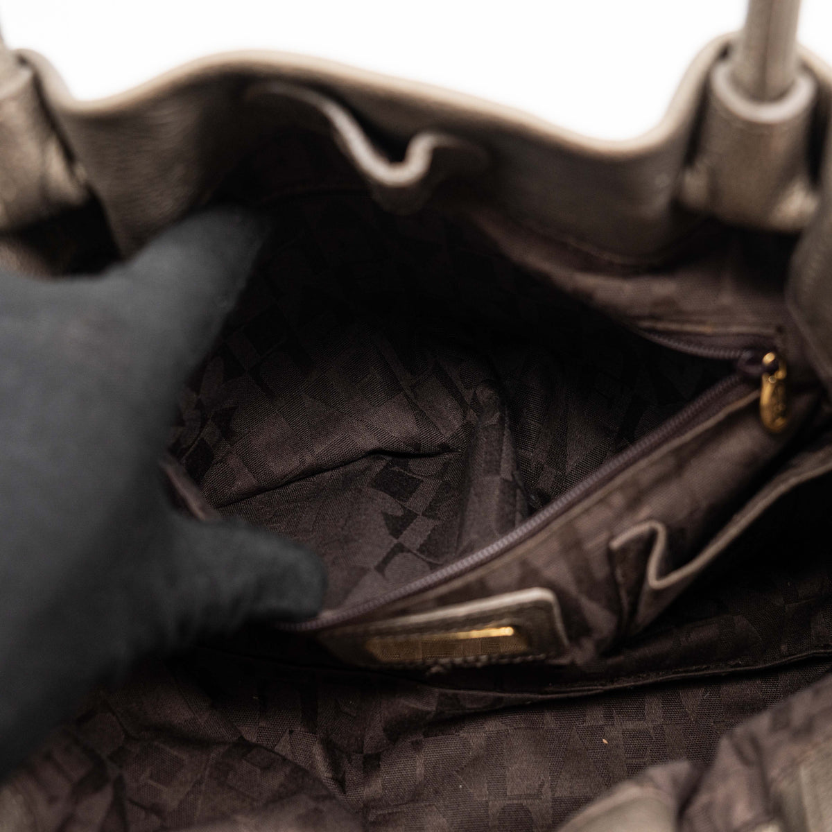 Furla taupe leather shoulder bag with gold hardware and braided detailing, photographed against a white background.