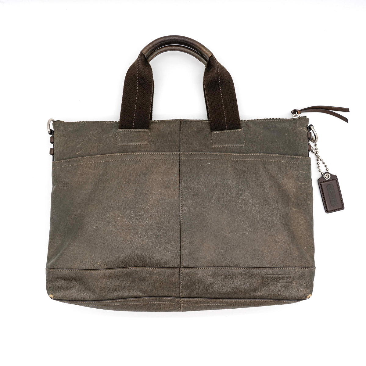 Coach brown leather tote bag with double handles and front zip pocket, shown on a white background.