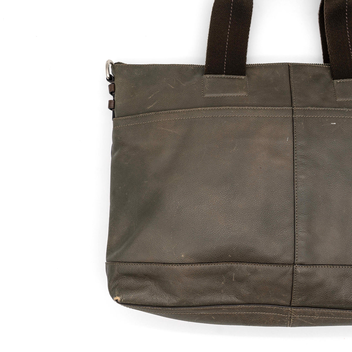 Coach brown leather tote bag with double handles and front zip pocket, shown on a white background.
