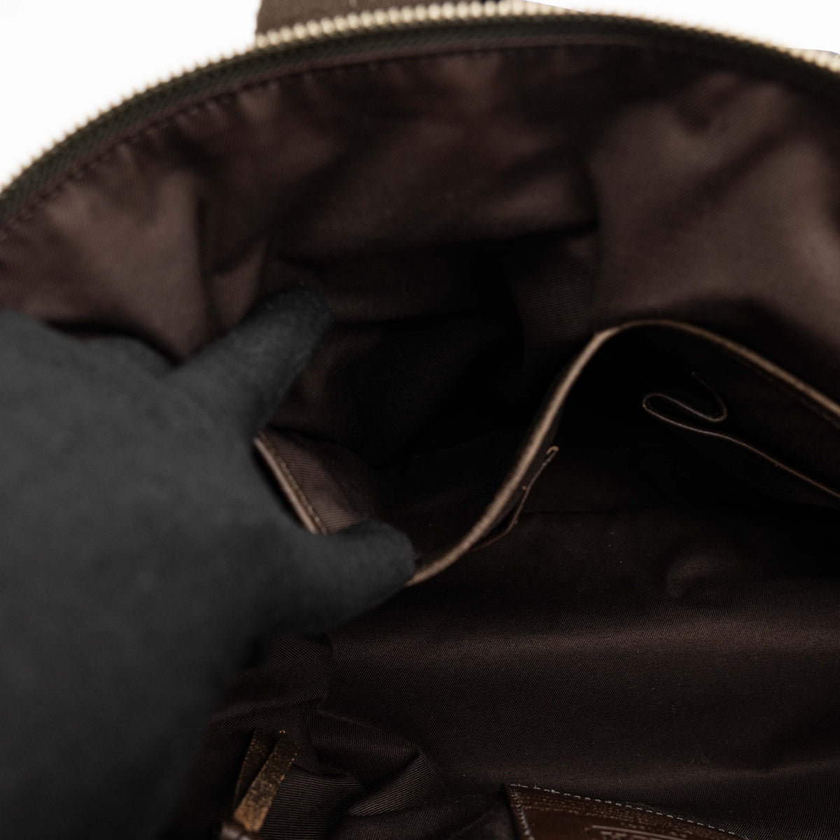 Coach brown leather tote bag with double handles and front zip pocket, shown on a white background.