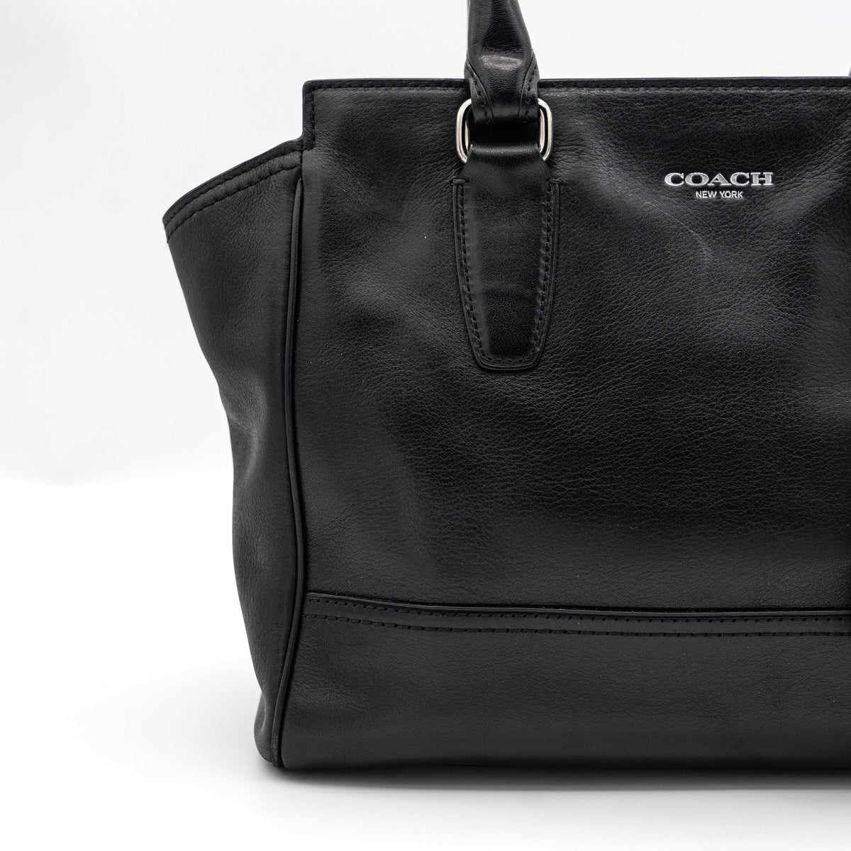 Coach Legacy Candace Carryall in black leather with double tassel charm and silver hardware, photographed against a white background.