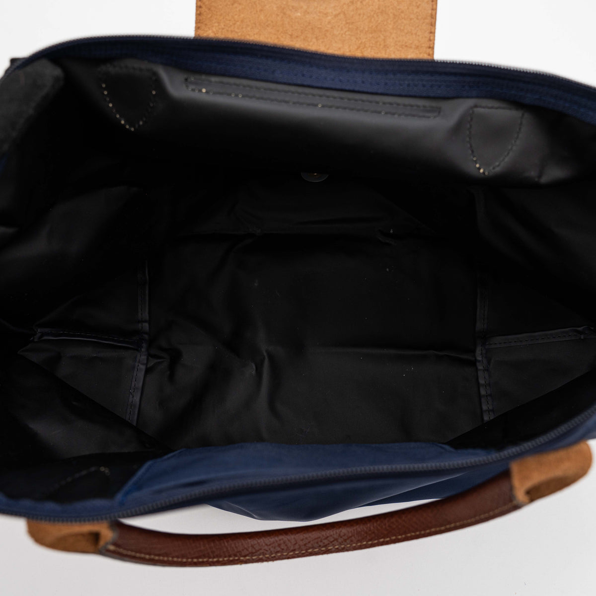 Longchamp Le Pliage Original handbag in navy blue nylon with brown leather handles and trim, shown against a white background.