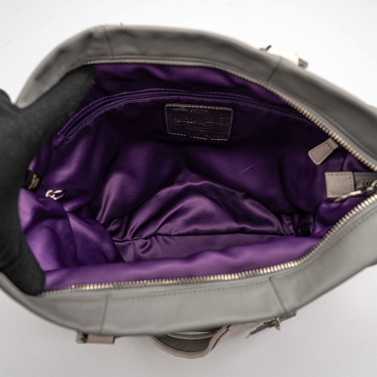 Coach Poppy Spotlight grey shoulder bag with double top handles, white trim, and detachable webbing strap, displayed on a white background.