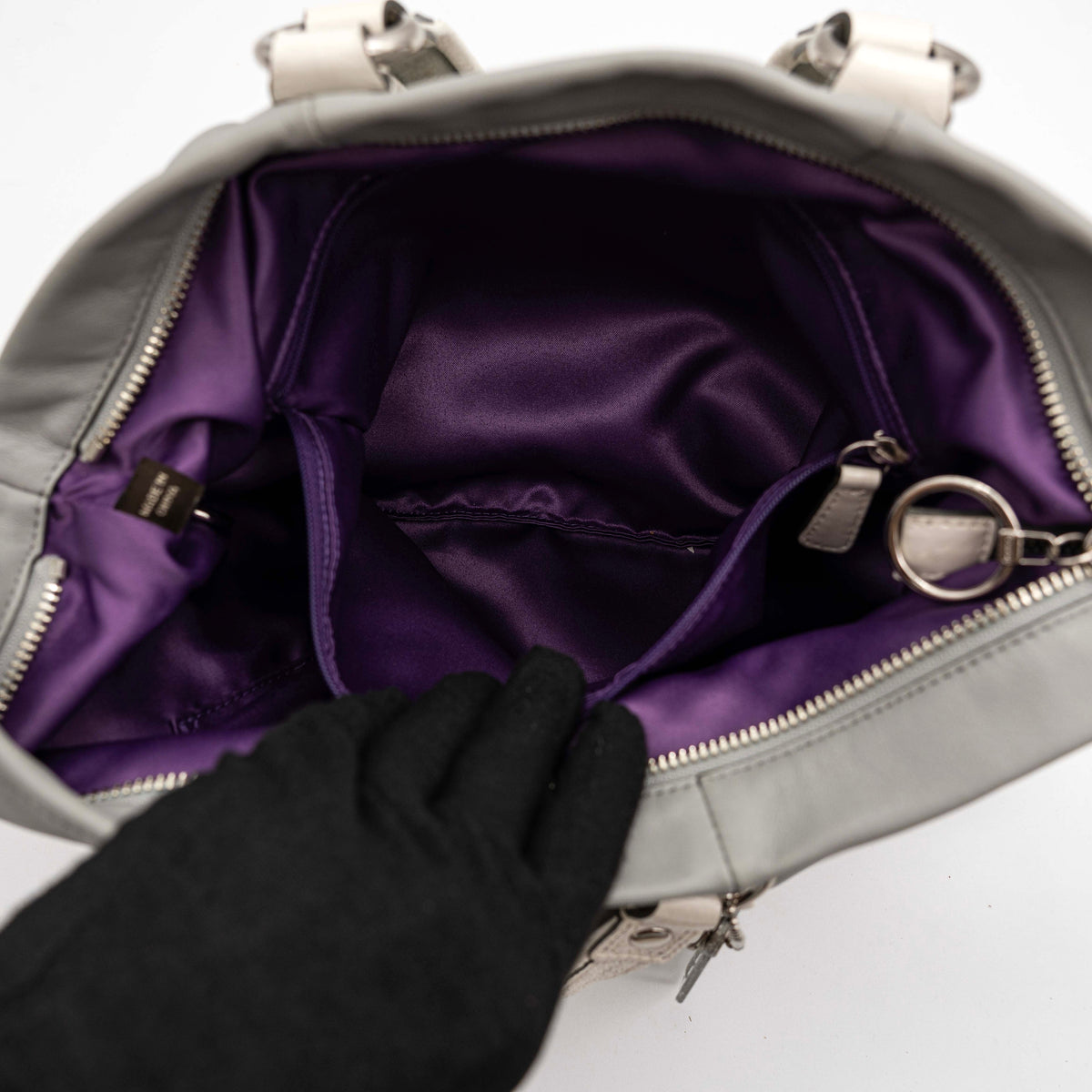 Coach Poppy Spotlight grey shoulder bag with double top handles, white trim, and detachable webbing strap, displayed on a white background.