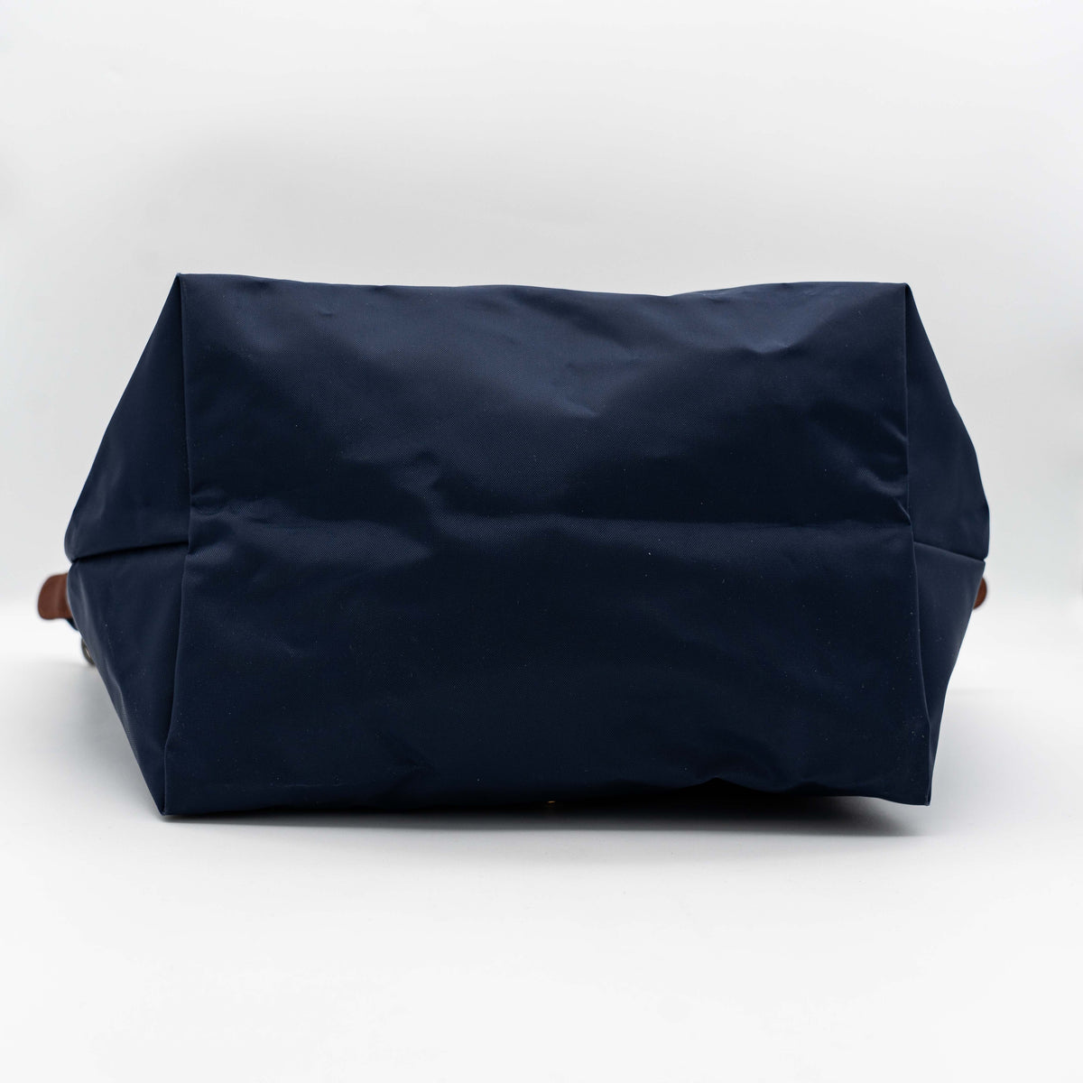 Longchamp Le Pliage Original handbag in navy blue nylon with brown leather handles and trim, shown against a white background.
