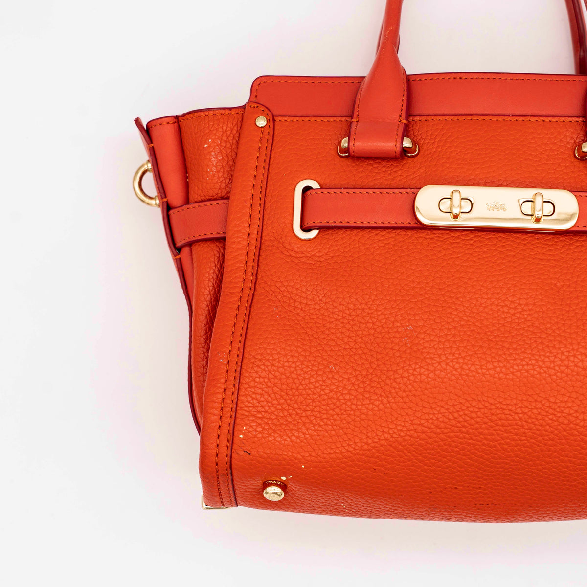 Coach Swagger 27 Carryall in textured red leather with gold hardware, shown with detachable shoulder strap.