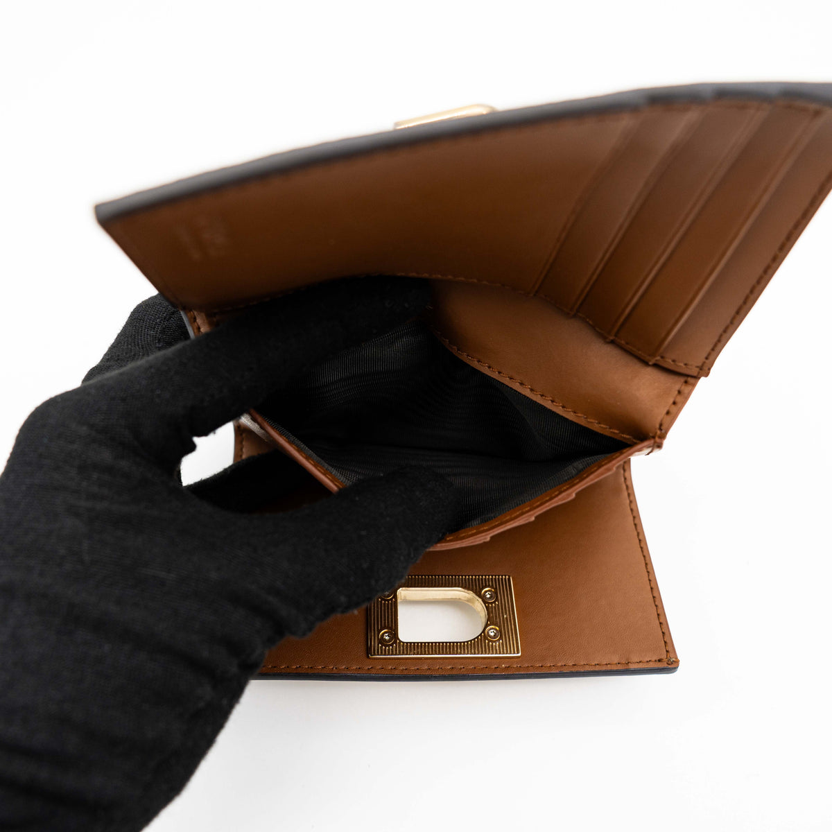 Furla 1927 M Compact Wallet in brown and black leather with gold hardware, photographed front facing on a white background.