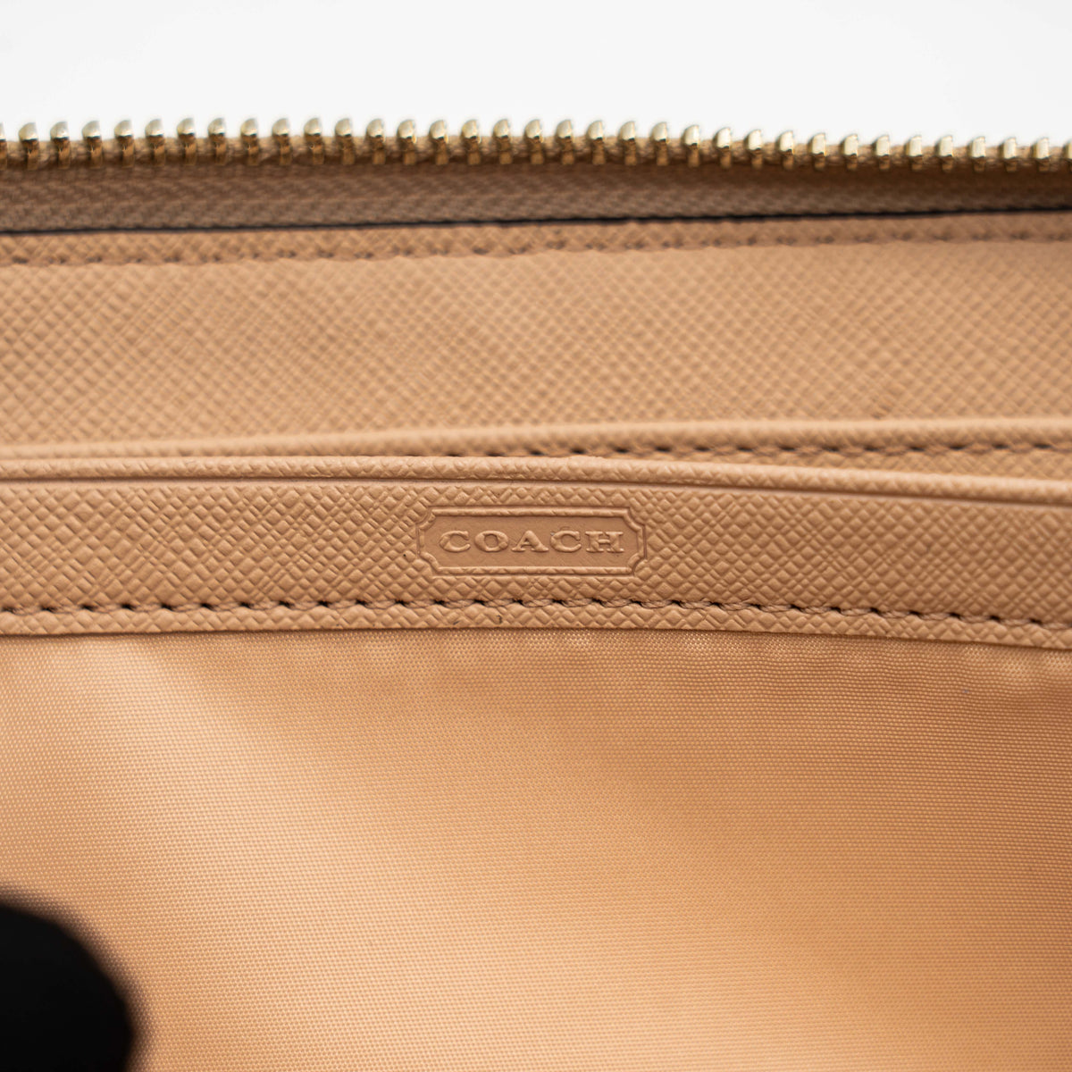 Coach Signature Daisy Accordion Zip Wallet in beige and pink canvas with zip pocket and metallic trim, photographed on a white background.
