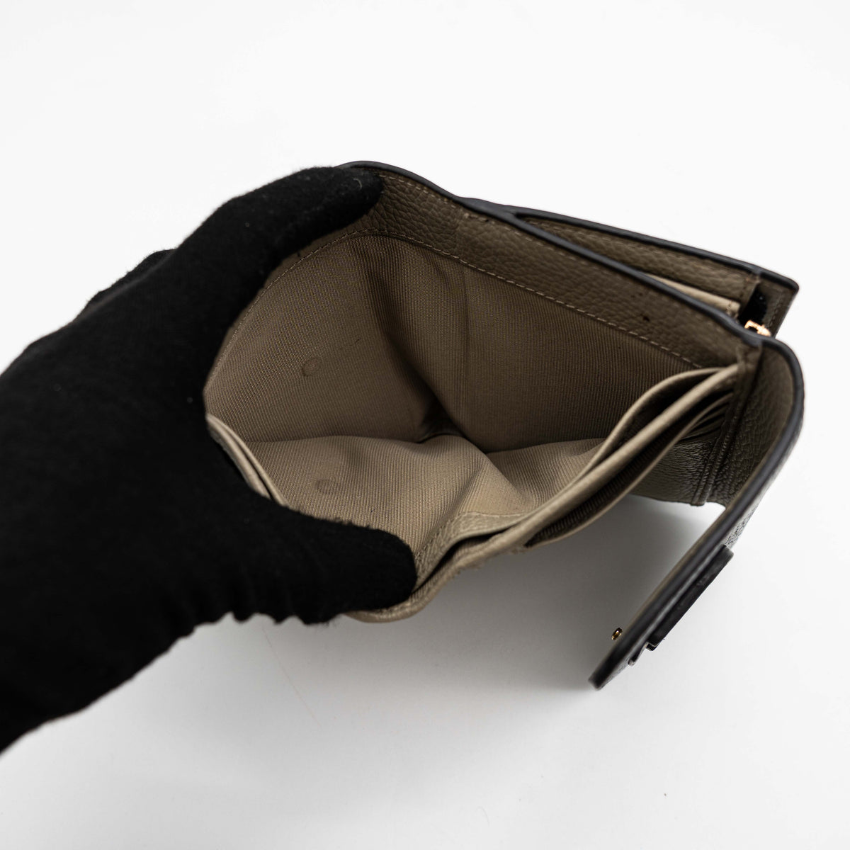 Furla Dafne black trifold wallet in pebbled leather with gold-tone hardware and logo plaque on the front.