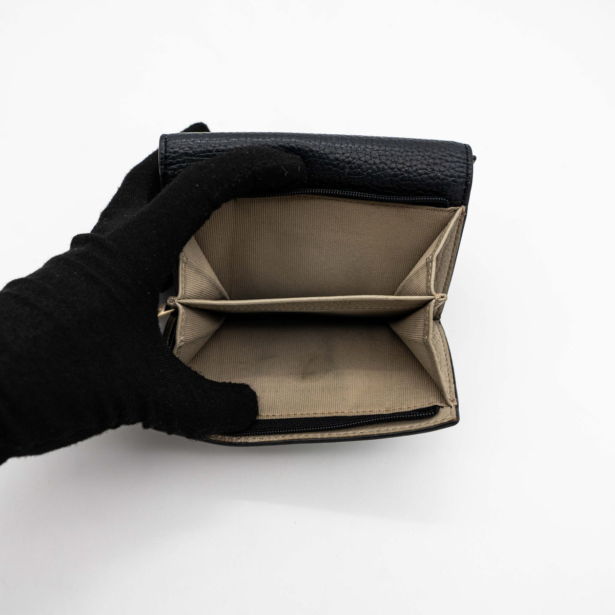 Furla Dafne black trifold wallet in pebbled leather with gold-tone hardware and logo plaque on the front.
