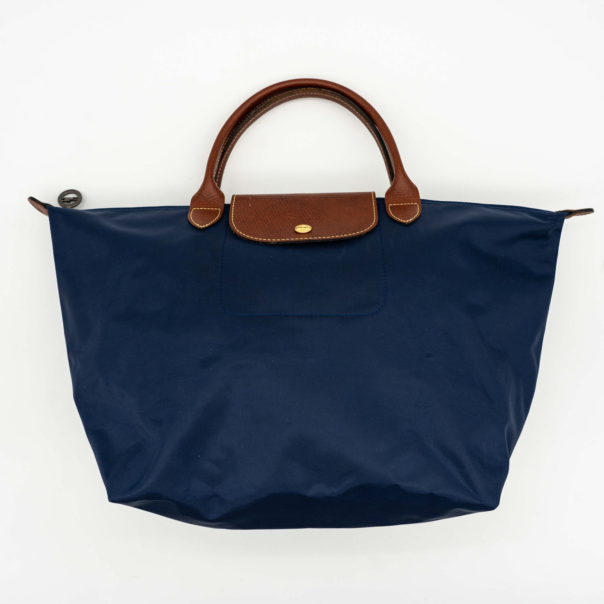 Longchamp Le Pliage Original handbag in navy blue nylon with brown leather handles and trim, shown against a white background.
