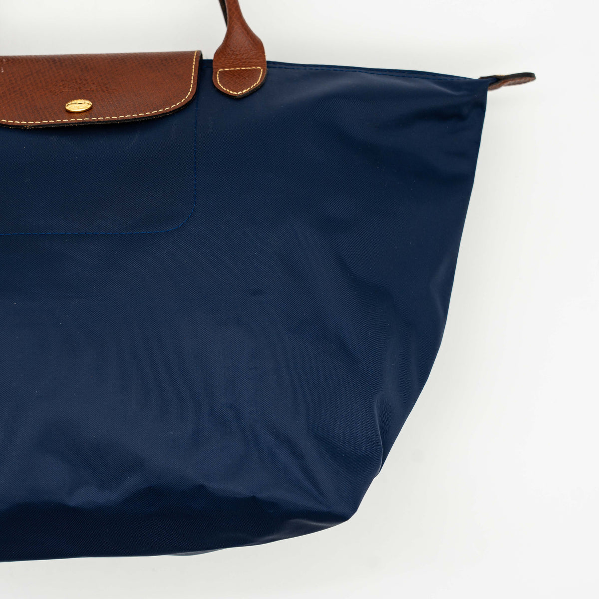 Longchamp Le Pliage Original handbag in navy blue nylon with brown leather handles and trim, shown against a white background.
