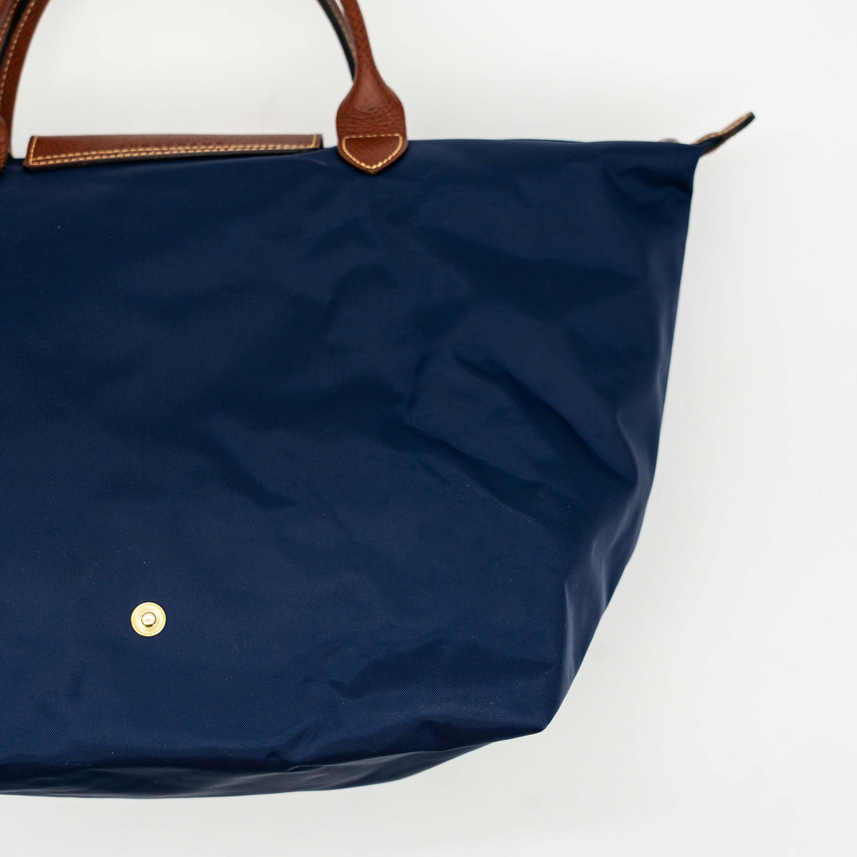 Longchamp Le Pliage Original handbag in navy blue nylon with brown leather handles and trim, shown against a white background.
