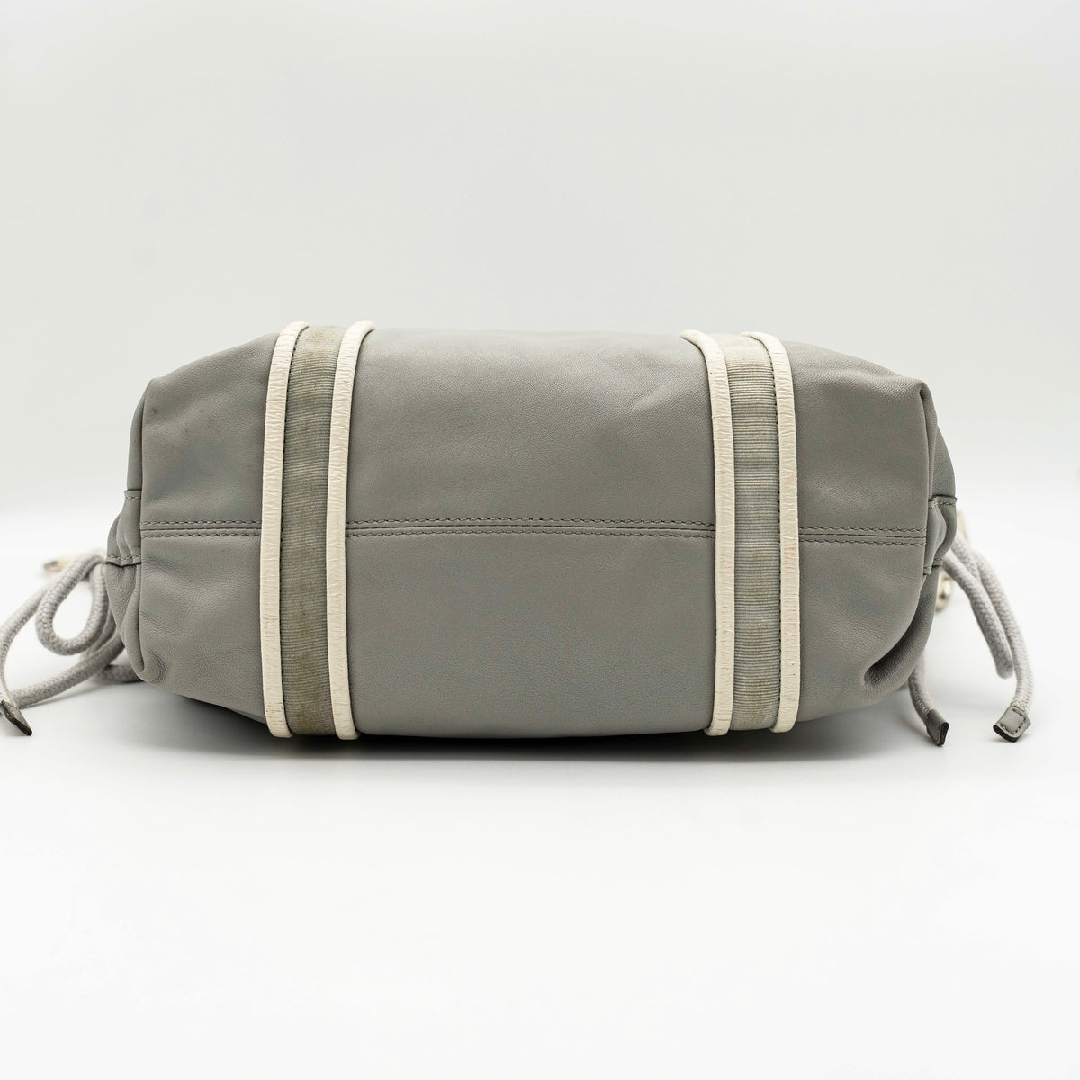 Coach Poppy Spotlight grey shoulder bag with double top handles, white trim, and detachable webbing strap, displayed on a white background.