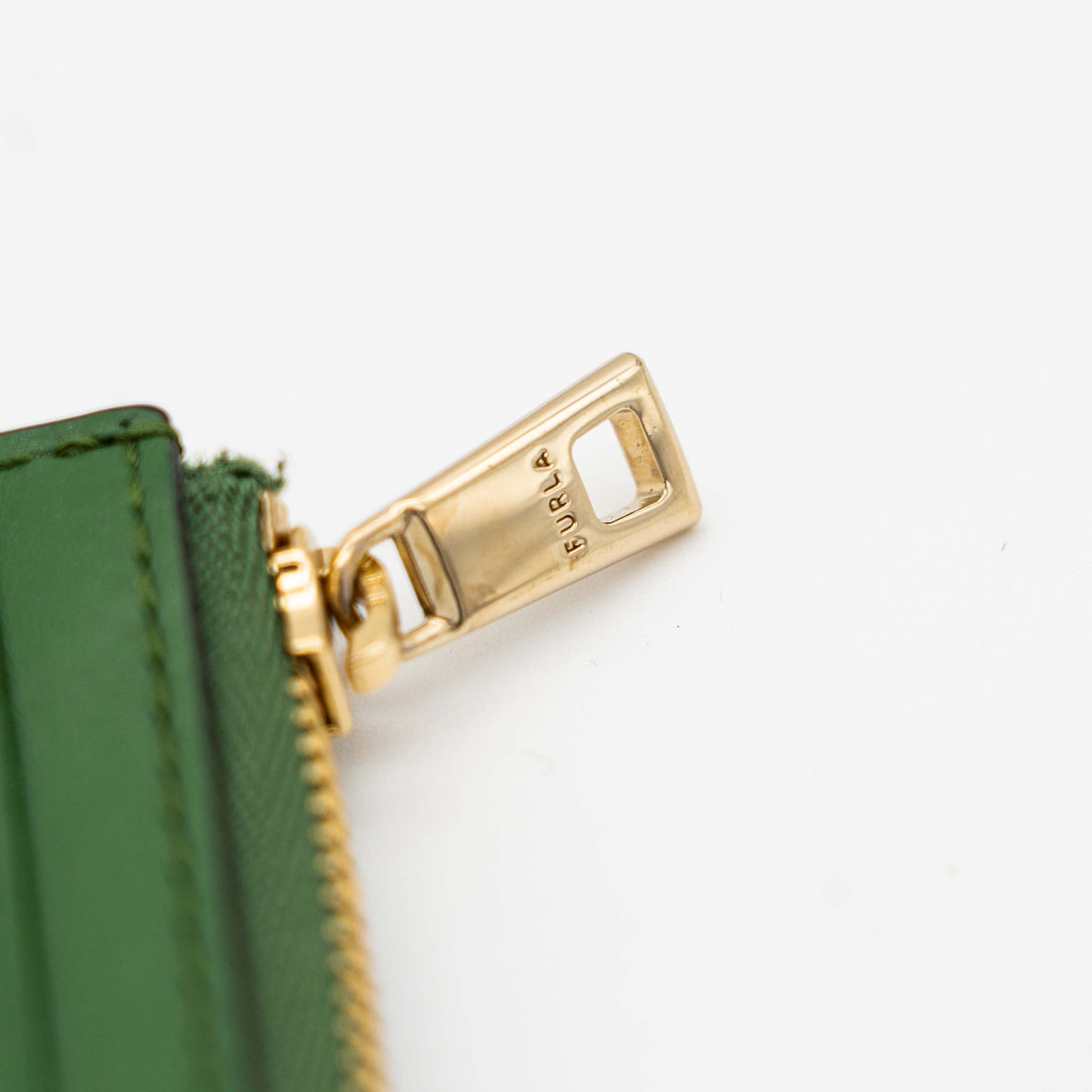 Furla Camelia S zipped card case in green leather with gold hardware and multiple card slots.