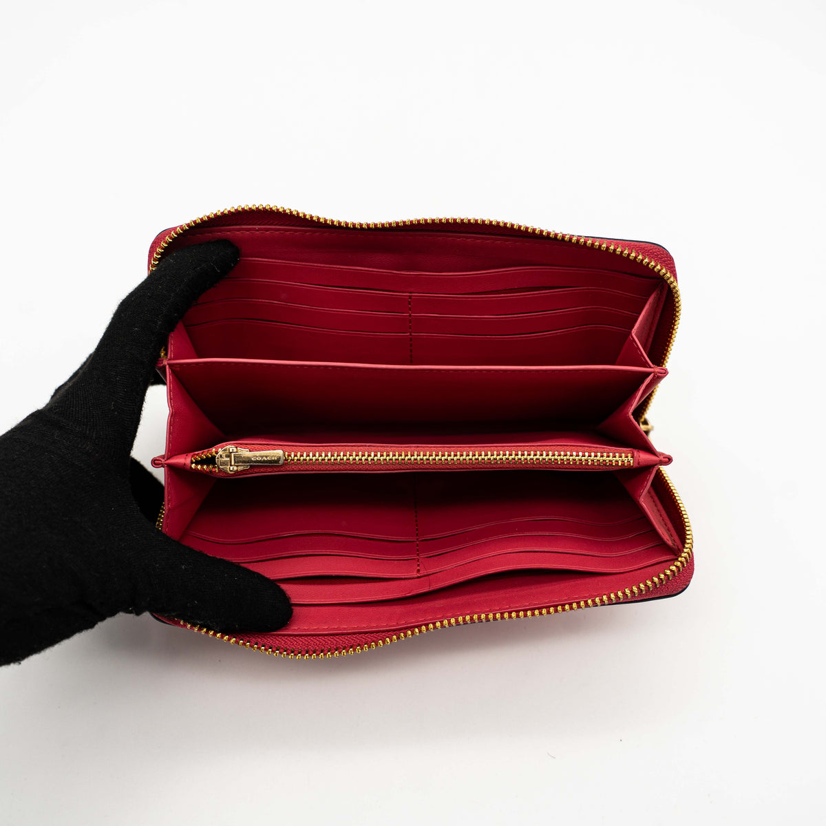 Coach Horse And Carriage Long Zip Around Wallet in red grained leather with gold-tone hardware and embossed logo, shown against a white background.