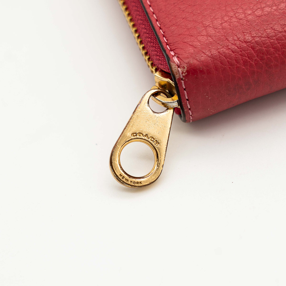 Coach Horse And Carriage Long Zip Around Wallet in red grained leather with gold-tone hardware and embossed logo, shown against a white background.