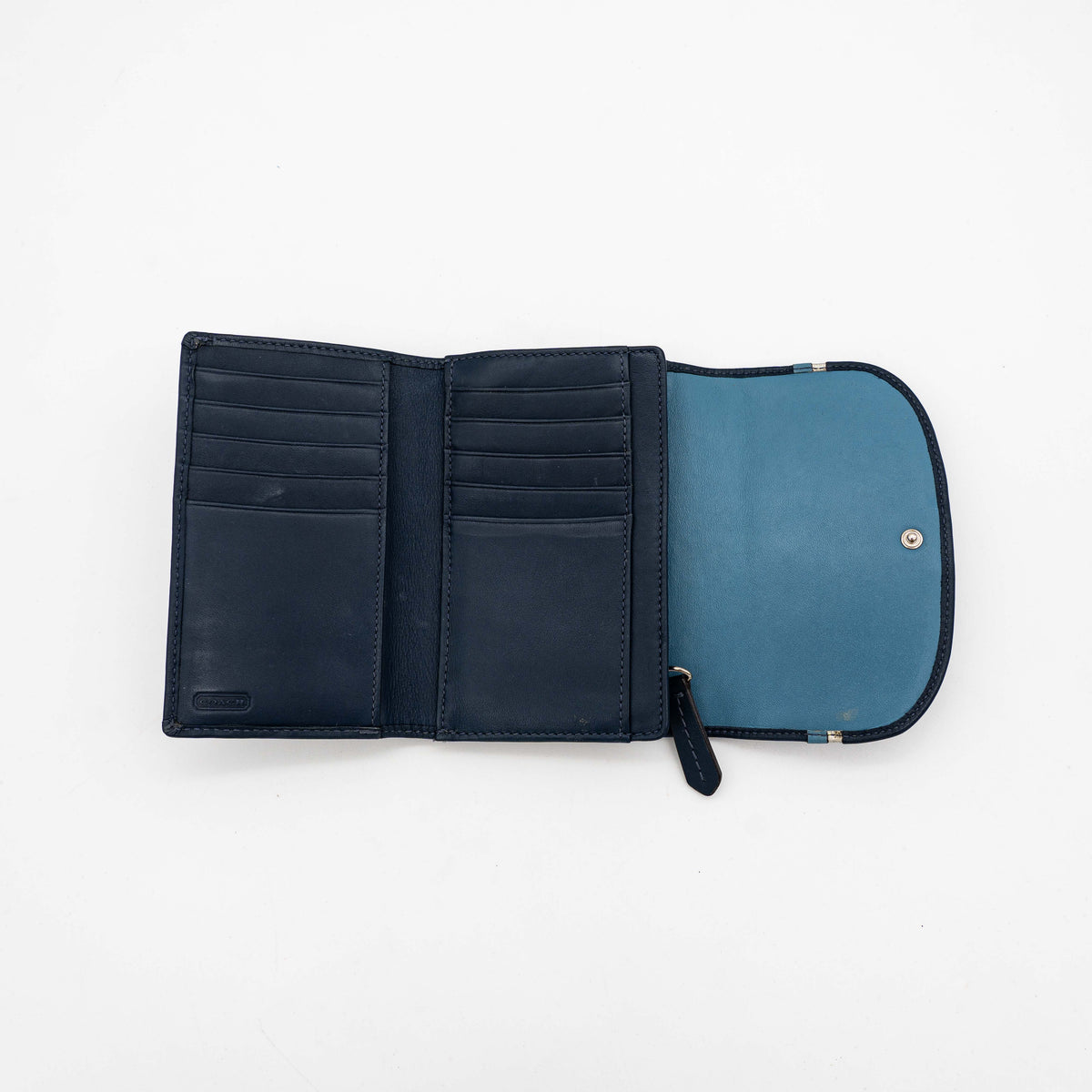 Coach Signature Ashley compact wallet in blue jacquard with leather trim, featuring a silver logo and organized interior.