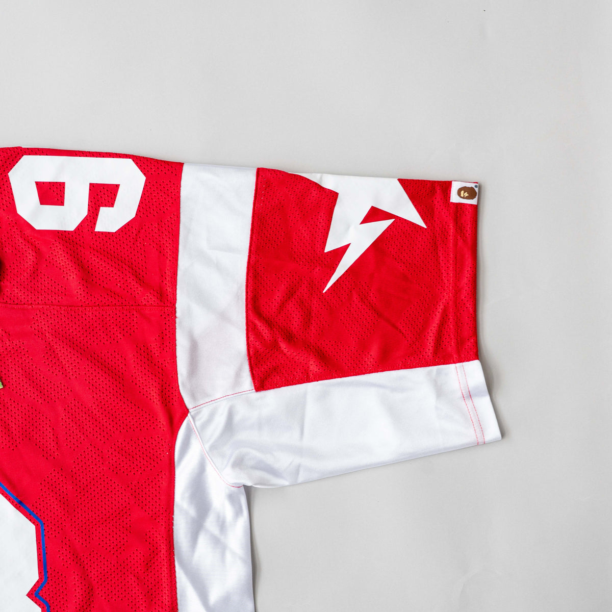 Front view of BAPE Solid Camo Jacquard Mesh Cropped Fit Football Jersey in red and white with bold '93' print and original tags.