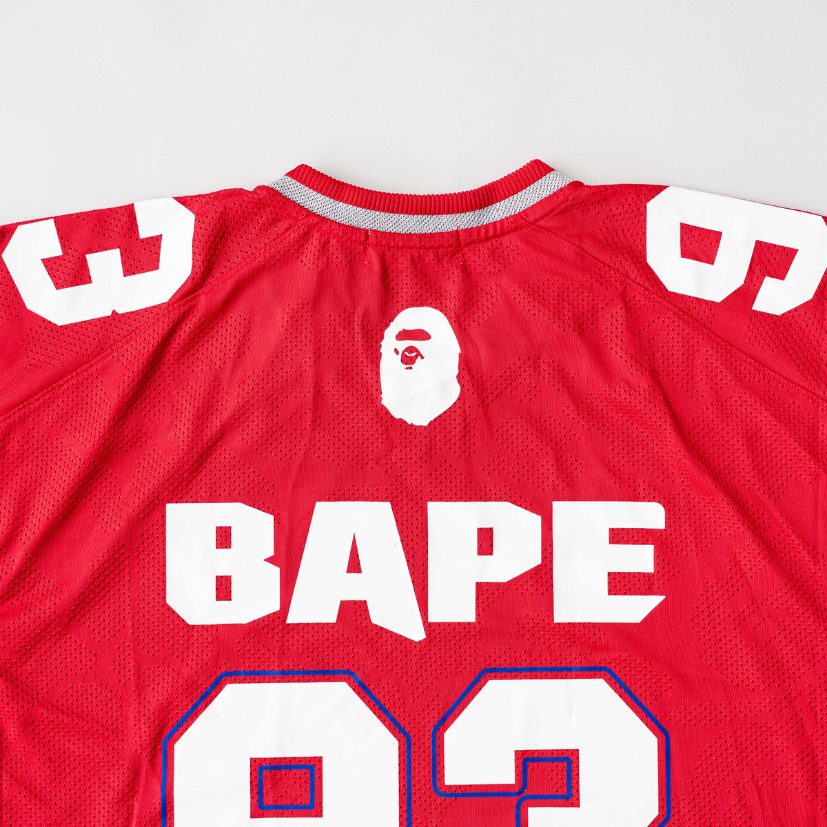 Front view of BAPE Solid Camo Jacquard Mesh Cropped Fit Football Jersey in red and white with bold '93' print and original tags.