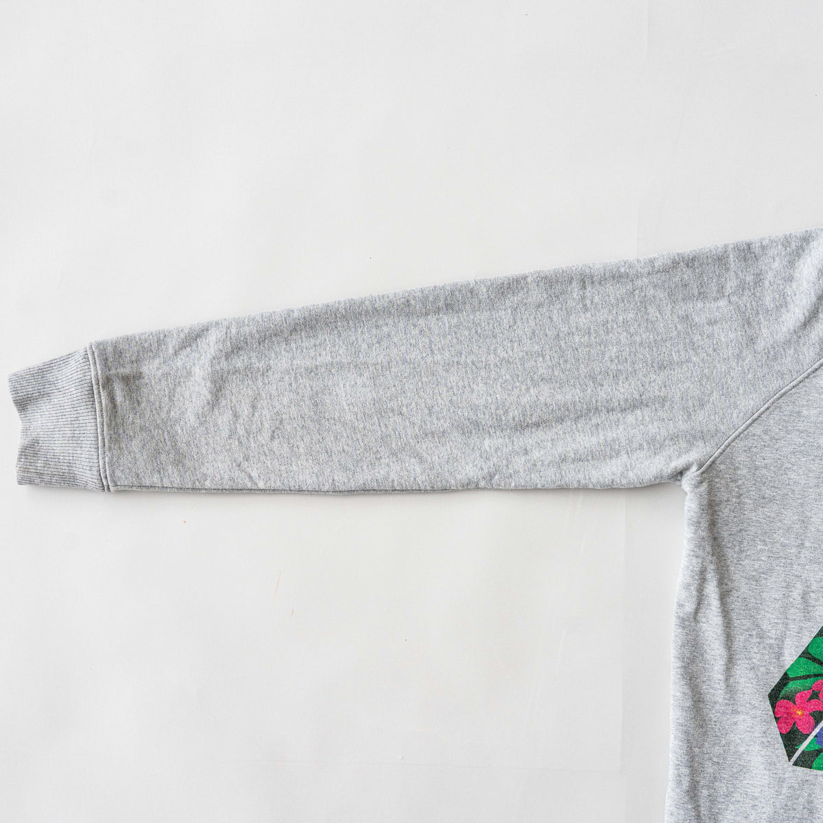 Palace grey pullover hoodie with tropical Tri-Ferg back graphic and white chest logo, laid flat on a neutral background.