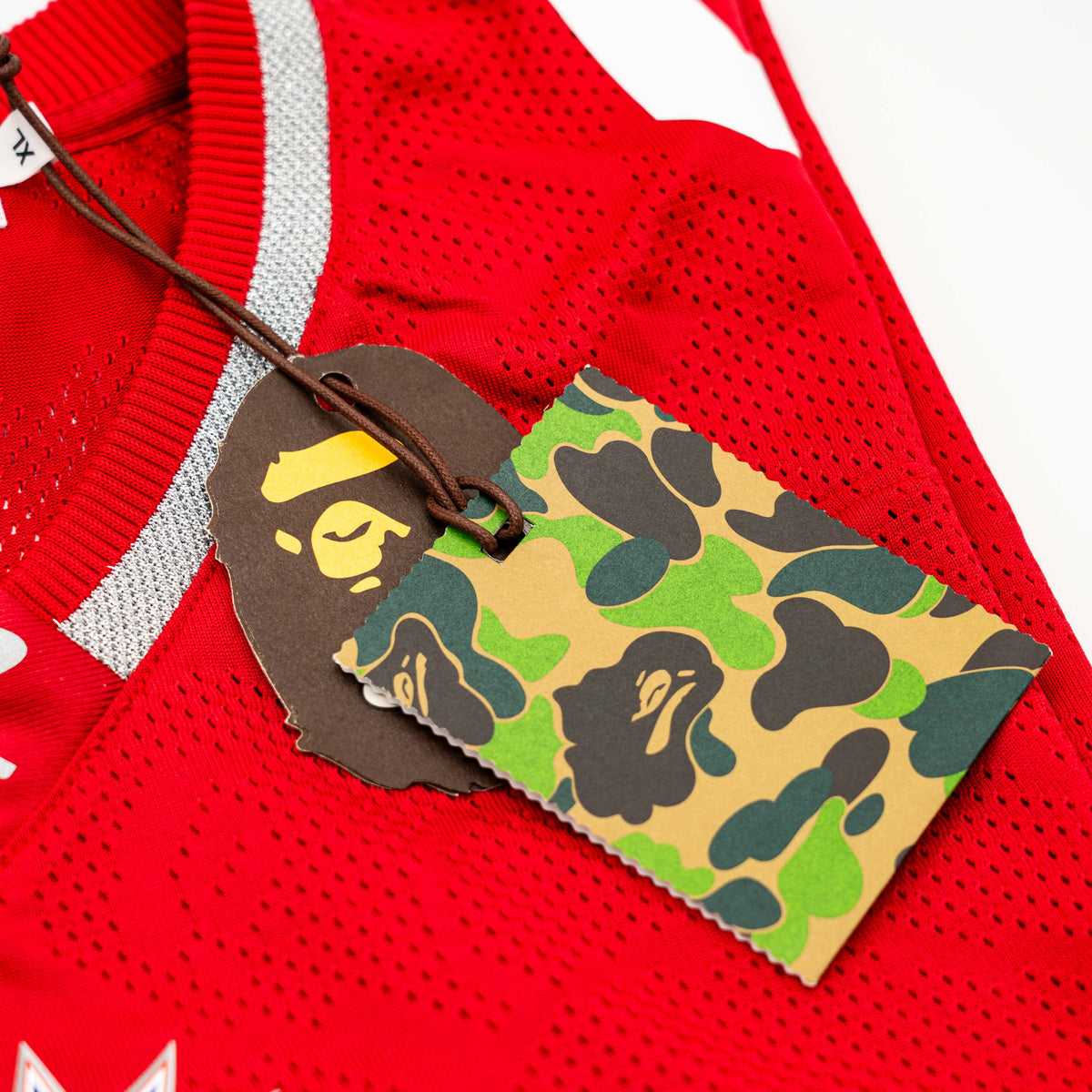 Front view of BAPE Solid Camo Jacquard Mesh Cropped Fit Football Jersey in red and white with bold '93' print and original tags.
