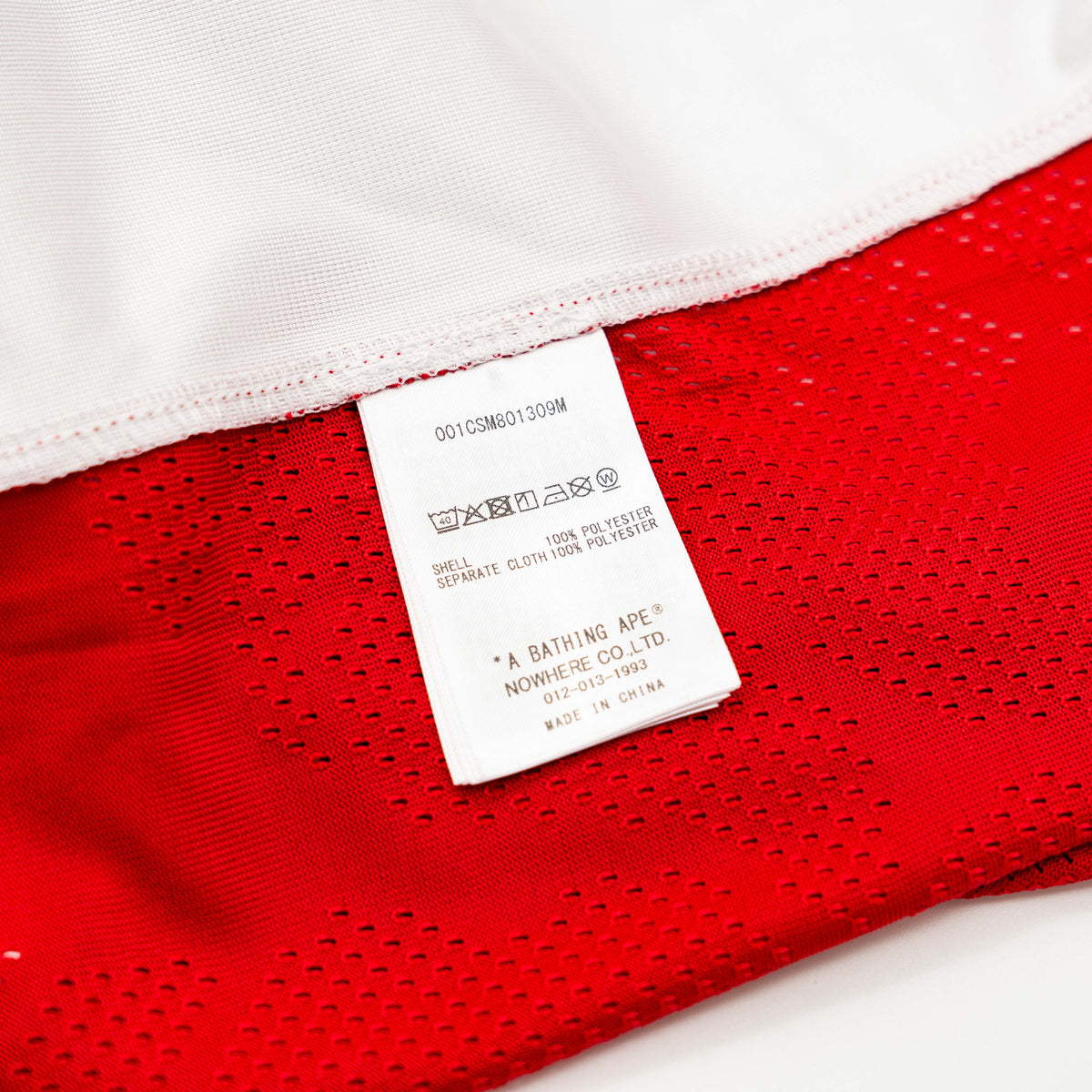 Front view of BAPE Solid Camo Jacquard Mesh Cropped Fit Football Jersey in red and white with bold '93' print and original tags.