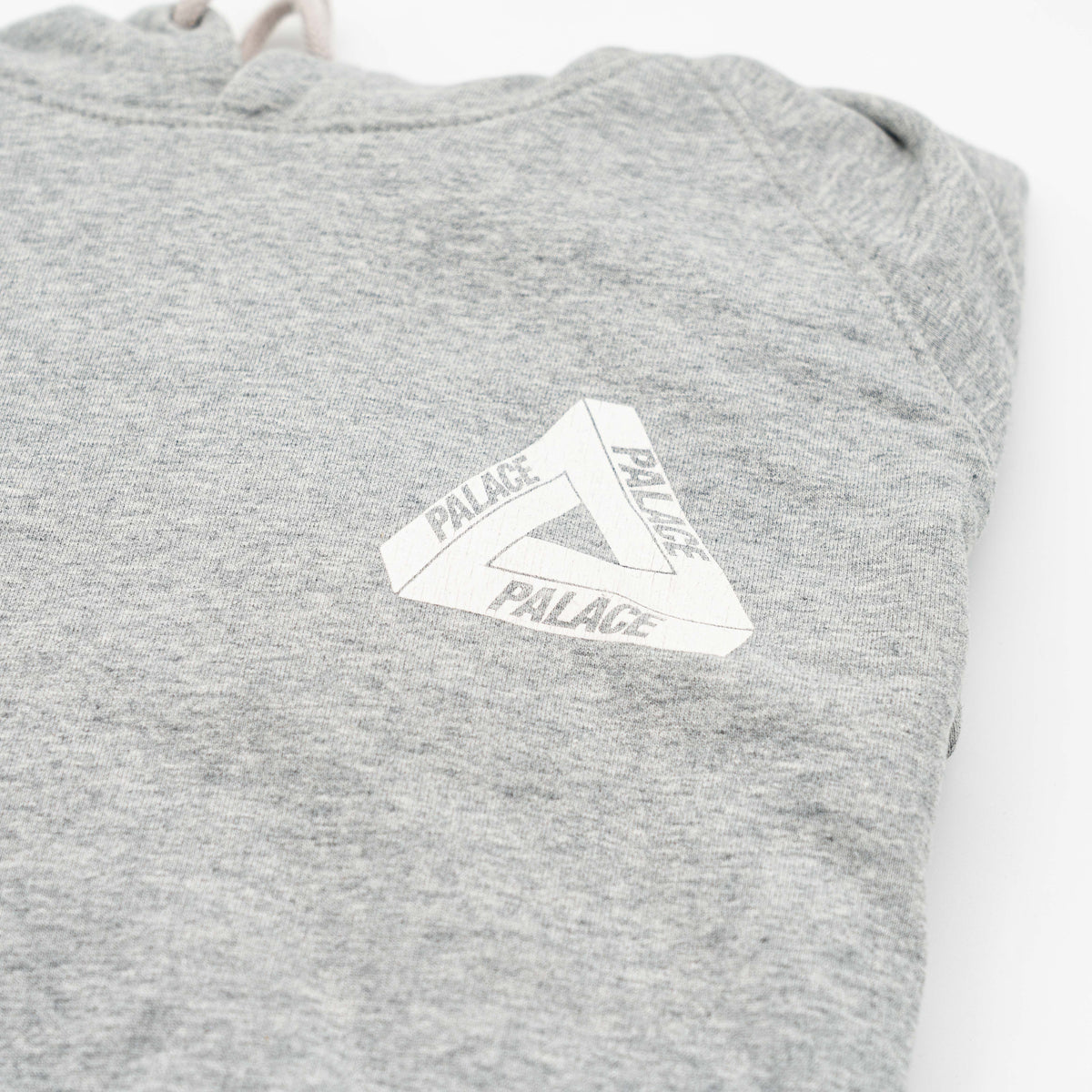 Palace grey pullover hoodie with tropical Tri-Ferg back graphic and white chest logo, laid flat on a neutral background.