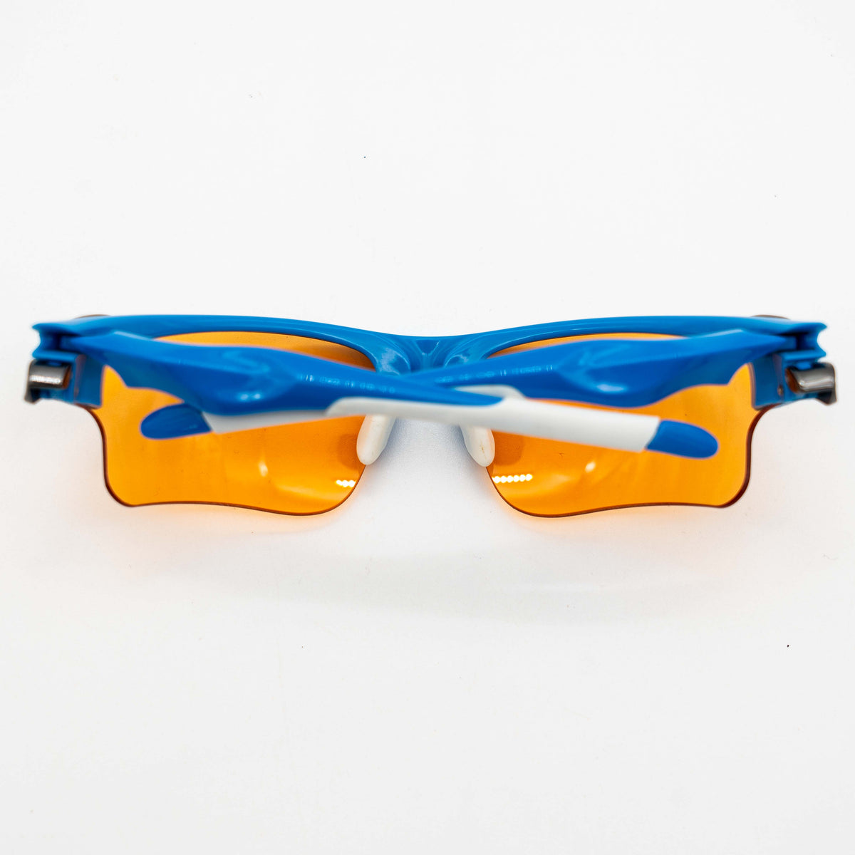 Oakley Fast Jacket OO9156-04 sunglasses in blue with orange lenses, displayed with two extra pairs of lenses, cleaning cloth and a black Oakley hard case.