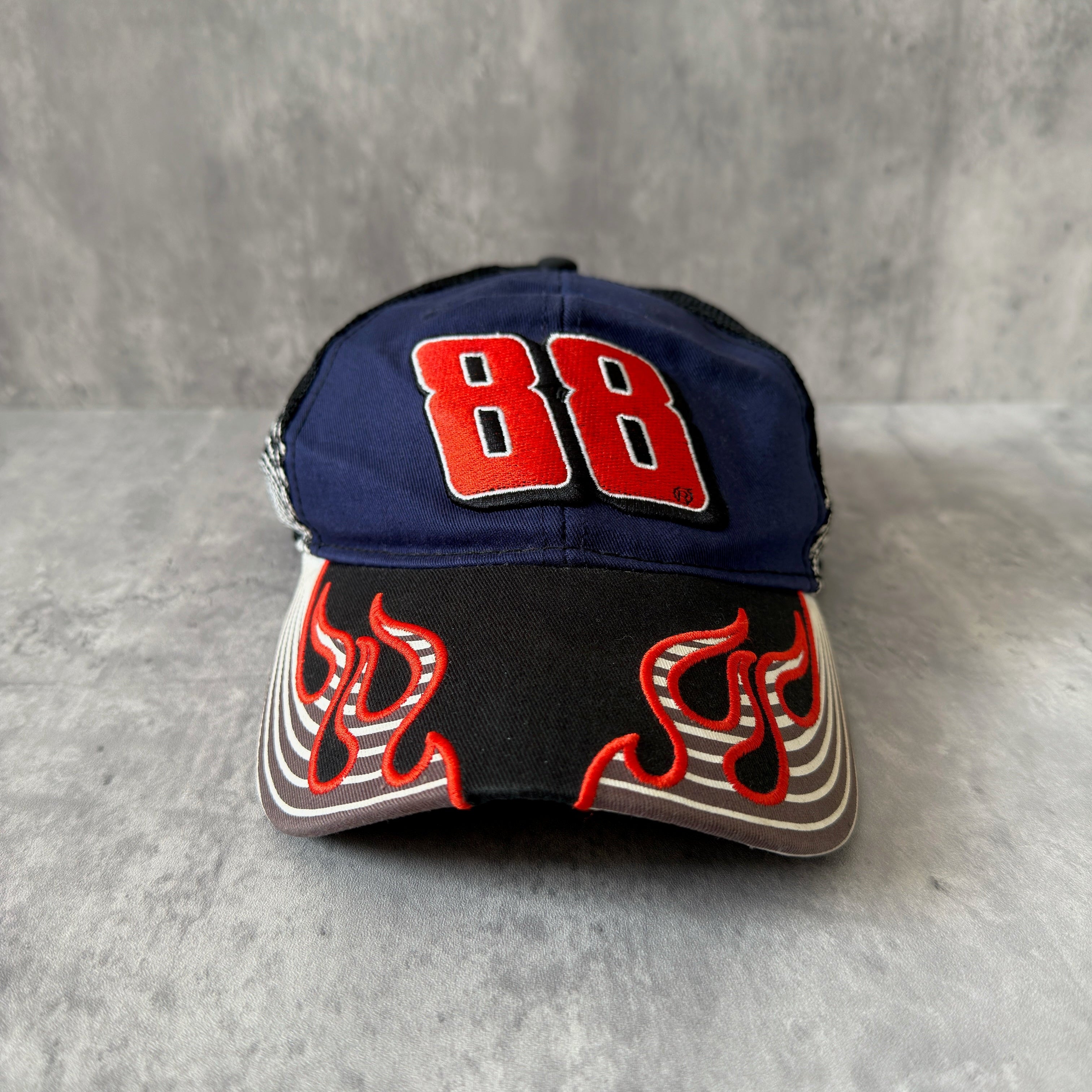Dale Earnhardt Jr. 88 NASCAR Hendrick Strapback Hat in navy and black, featuring flame embroidery on the brim, Dale Jr.'s signature on the side, and an adjustable strapback closure.
