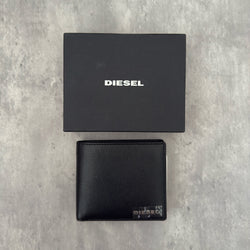 Diesel Signature Leather Wallet in black with contrast orange interior, featuring a metal logo plaque and multiple compartments.