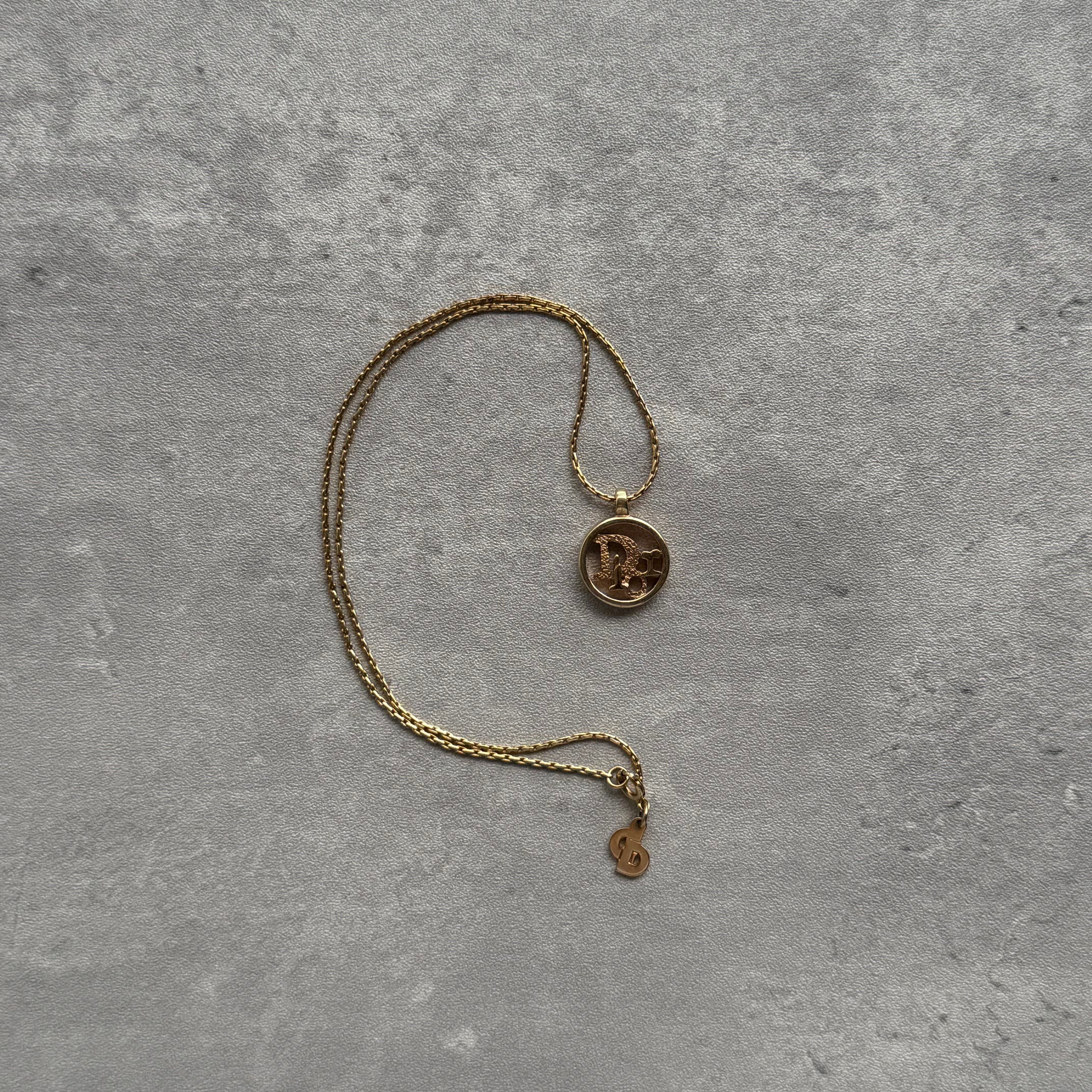 Dior Logo Pendant Necklace, gold-plated with circular charm and rhinestone detailing on a fine link chain.