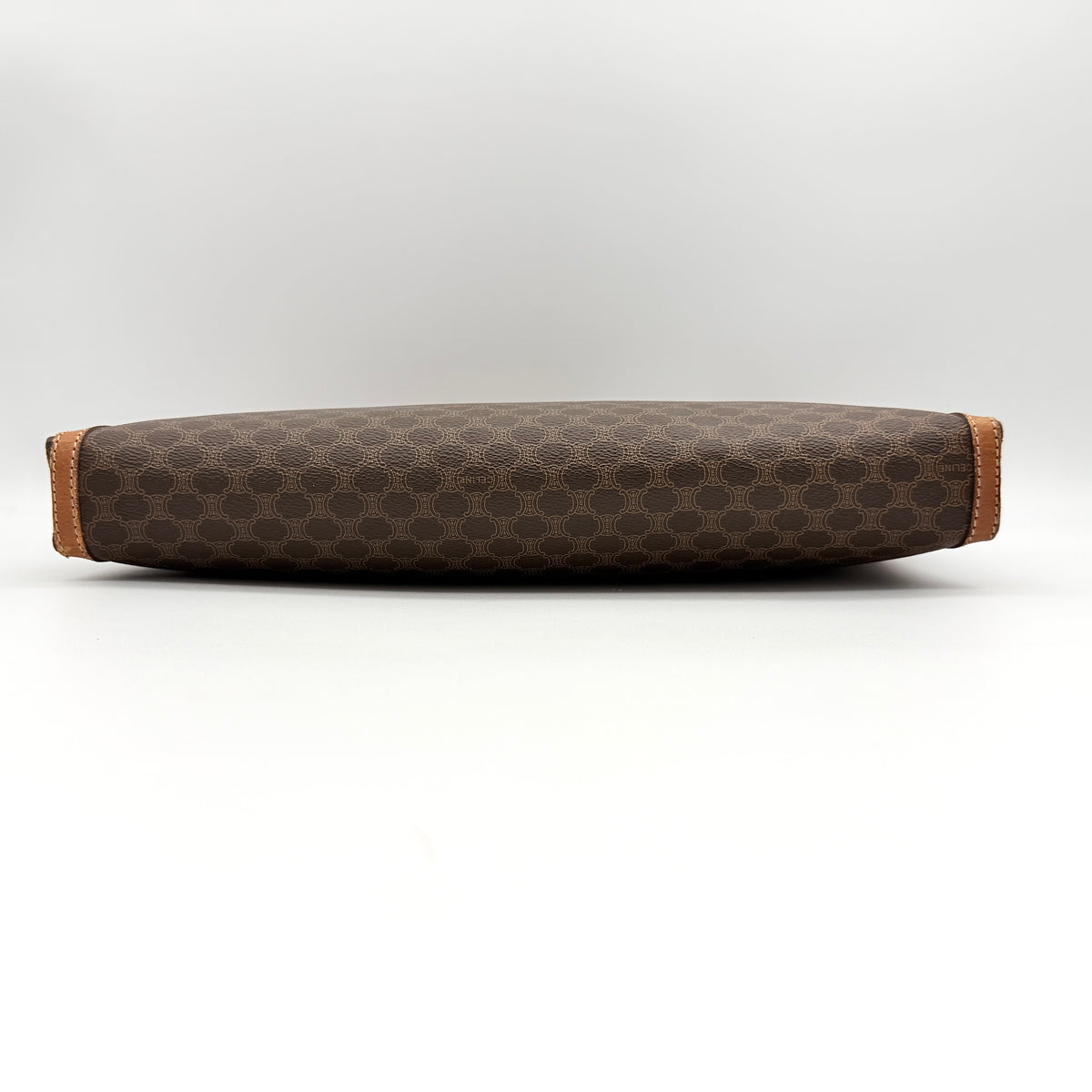 Celine Triomphe Macadam Clutch Bag in brown coated canvas with leather trim, shown against a white background.