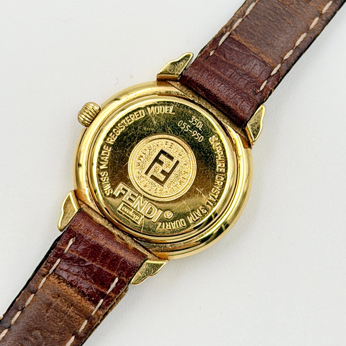 Fendi 350L Orologi Quartz Watch in gold with brown leather strap, displayed with original box and booklet.