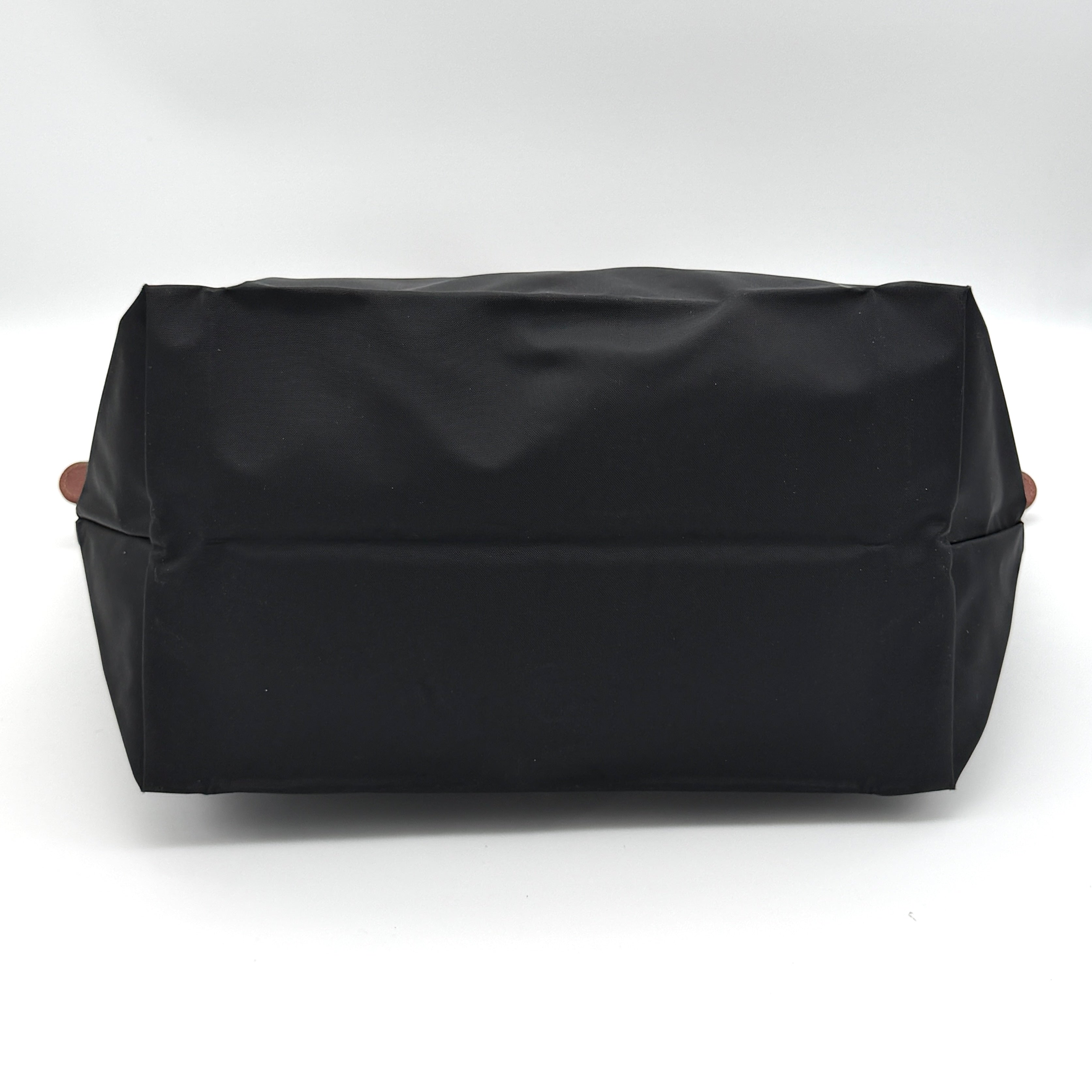 Longchamp Le Pliage Original Tote Bag in black with brown leather handles and flap, photographed against a white background.