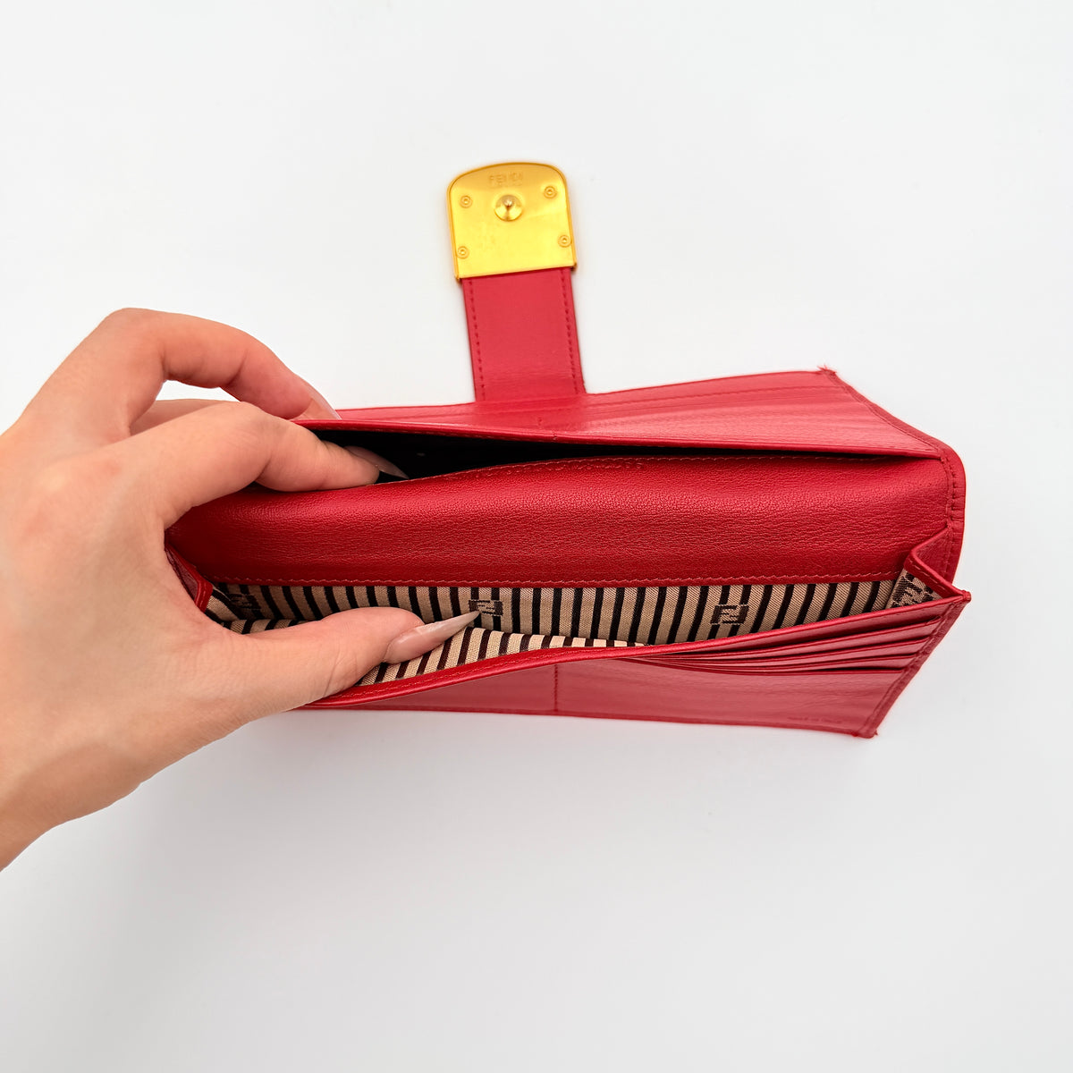 Fendi FF Logo Buckle Flap Continental Wallet in red leather with gold hardware, displayed closed on a white background.