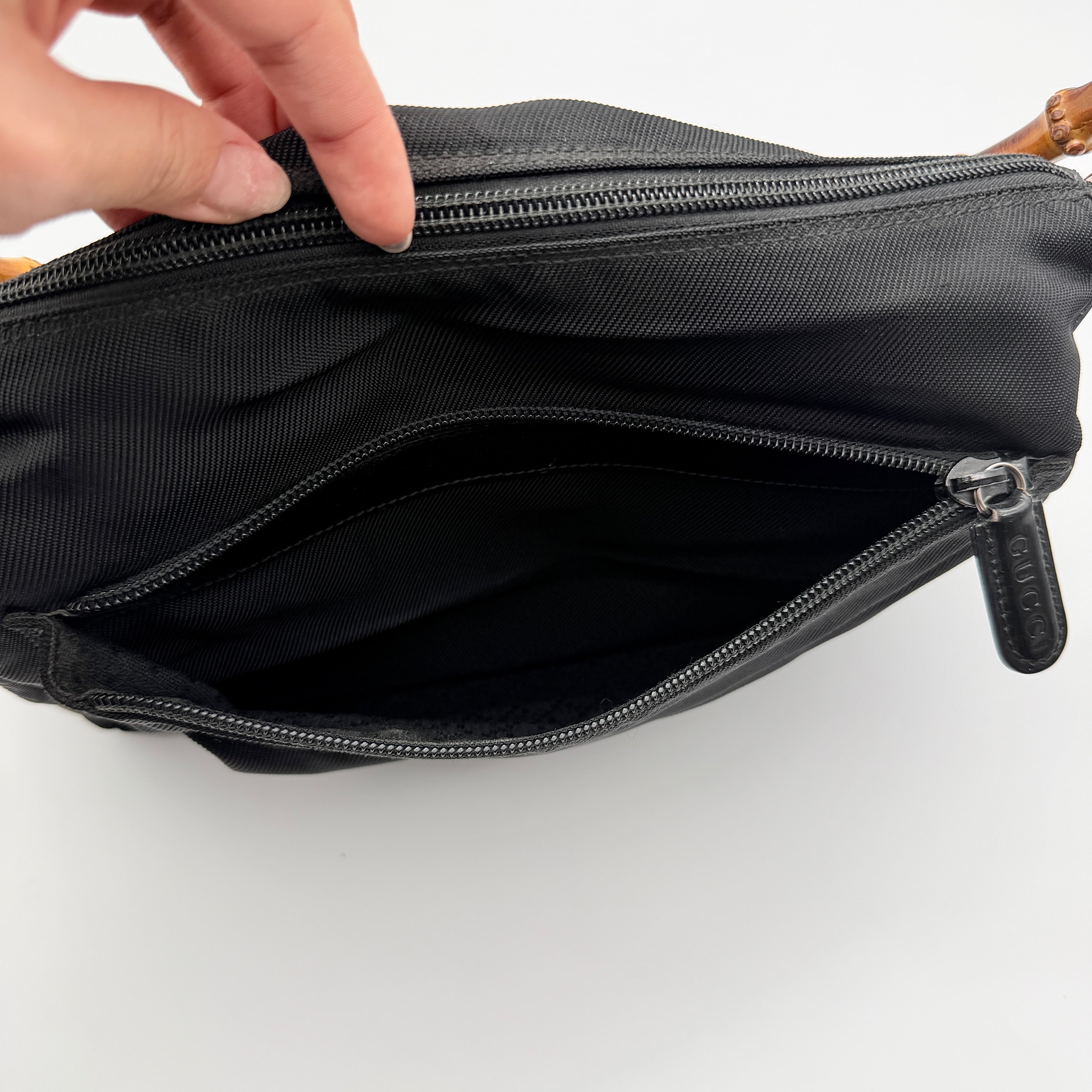Gucci nylon shoulder bag in black with bamboo handle, shown against a white background.