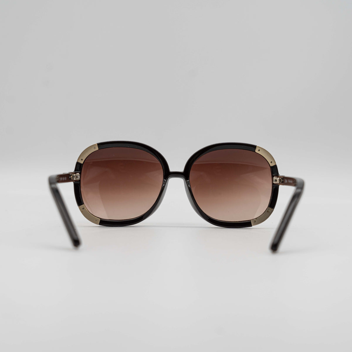 Chloé CL2119 sunglasses in black with gold-tone accents and brown gradient lenses, displayed at an angle.