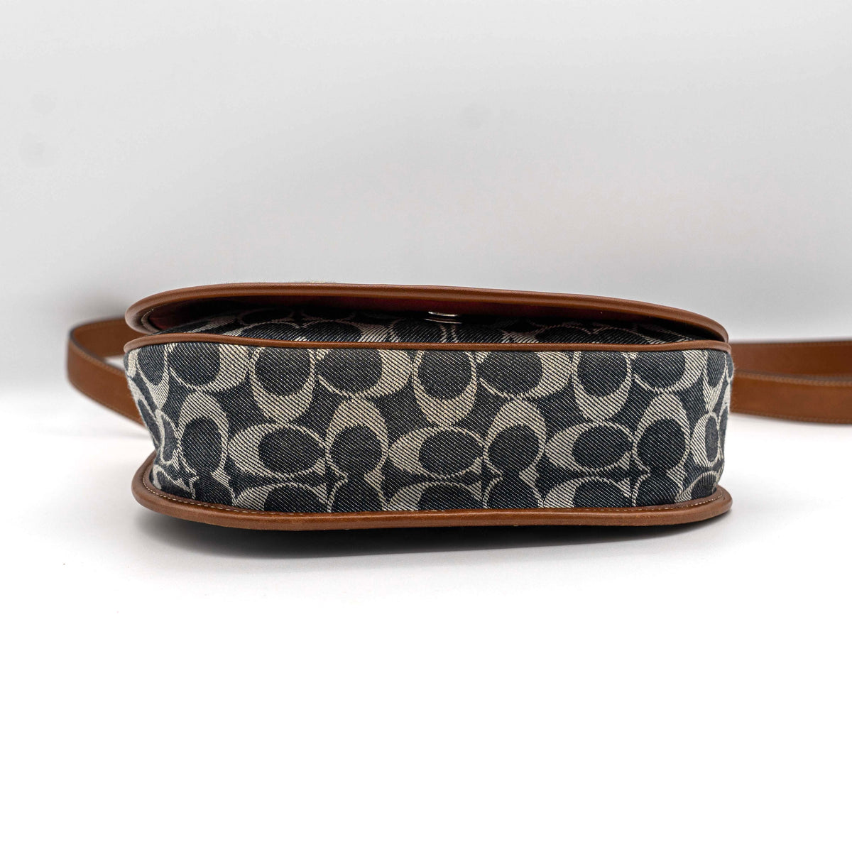 Coach signature denim hobo crossbody bag with red and blue stripe, brown leather trim, and an adjustable strap.