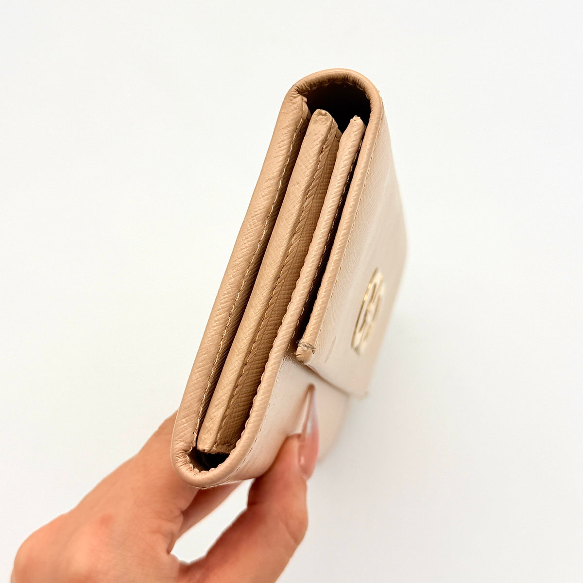 Salvatore Ferragamo light pink Saffiano wallet with gold Gancini hardware, shown on a white background.