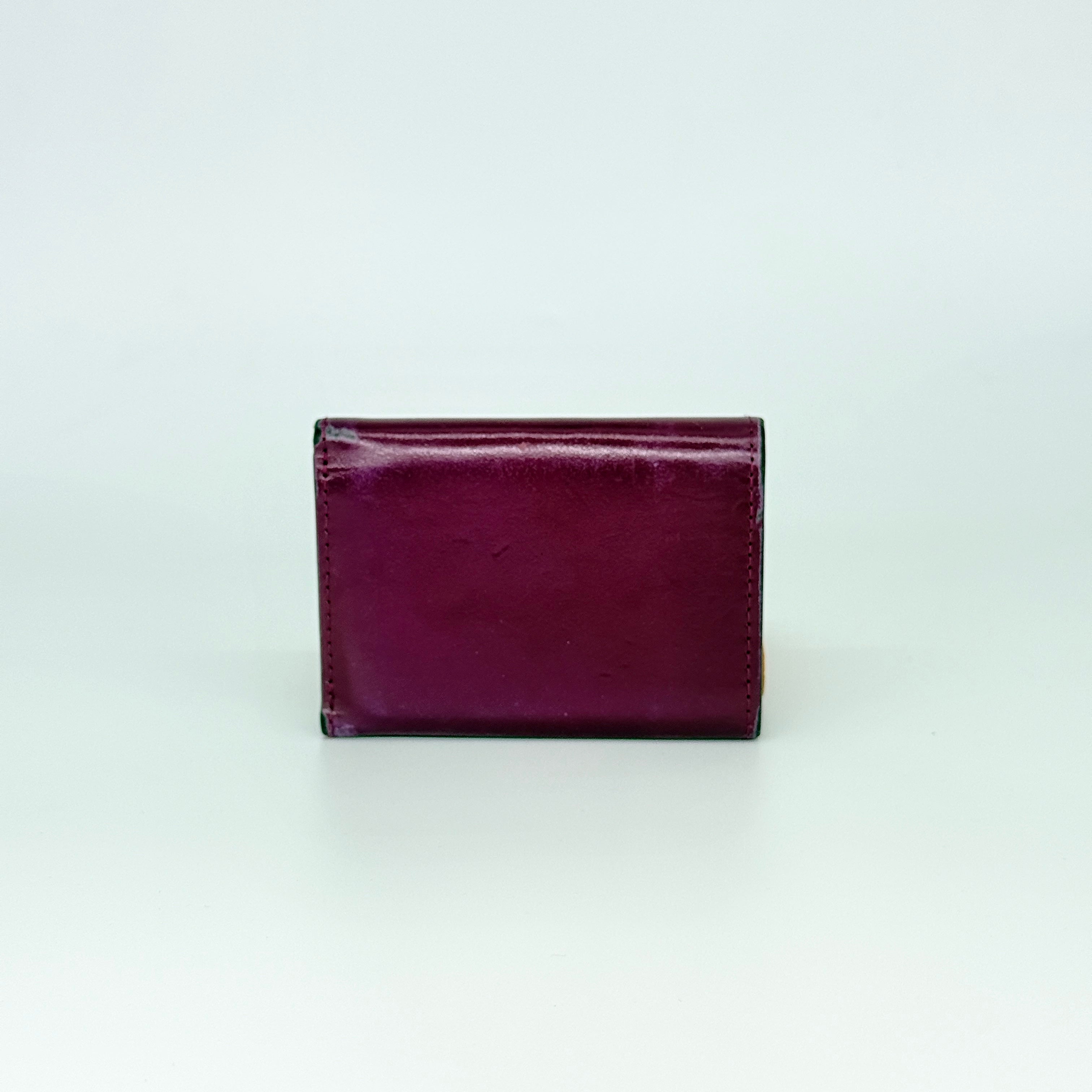 Vivienne Westwood Signature Orb Wallet in glossy purple leather with silver orb emblem on the front flap.