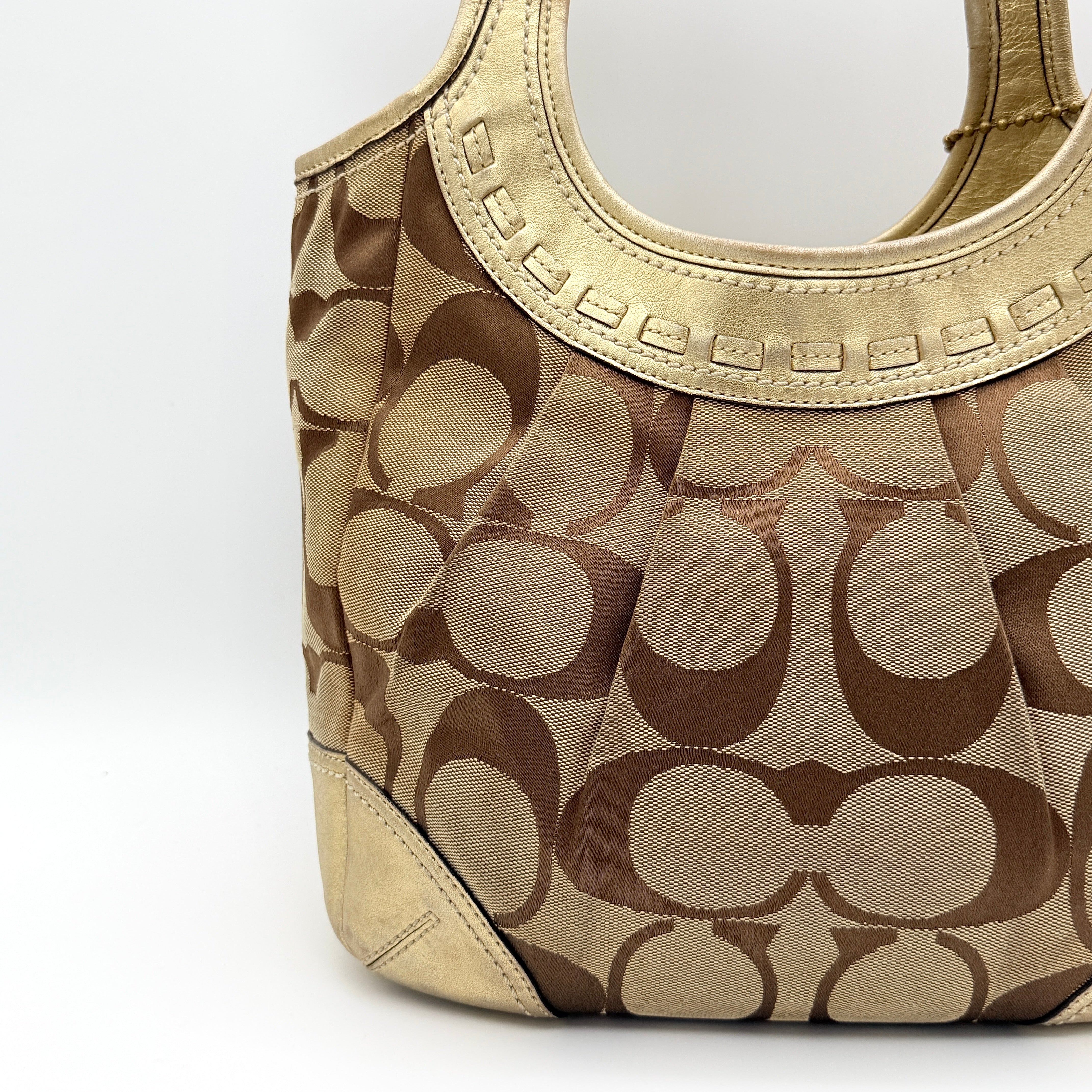 Coach Ergo Hobo Shoulder Bag in beige jacquard canvas with gold leather trim, shown standing upright against a white background.