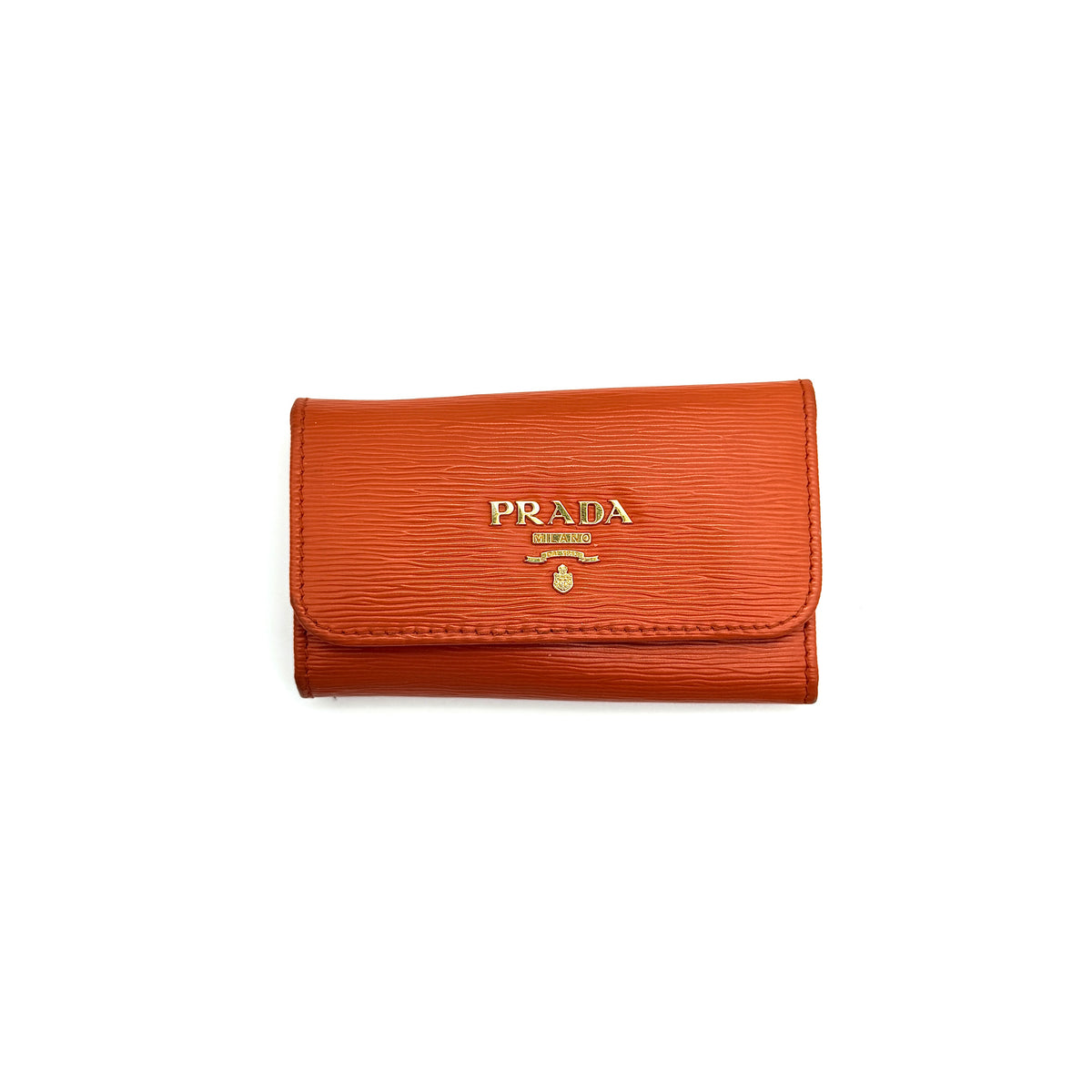 Prada Saffiano leather key case in orange with gold-toned hardware, Prada logo, and authenticity card displayed.