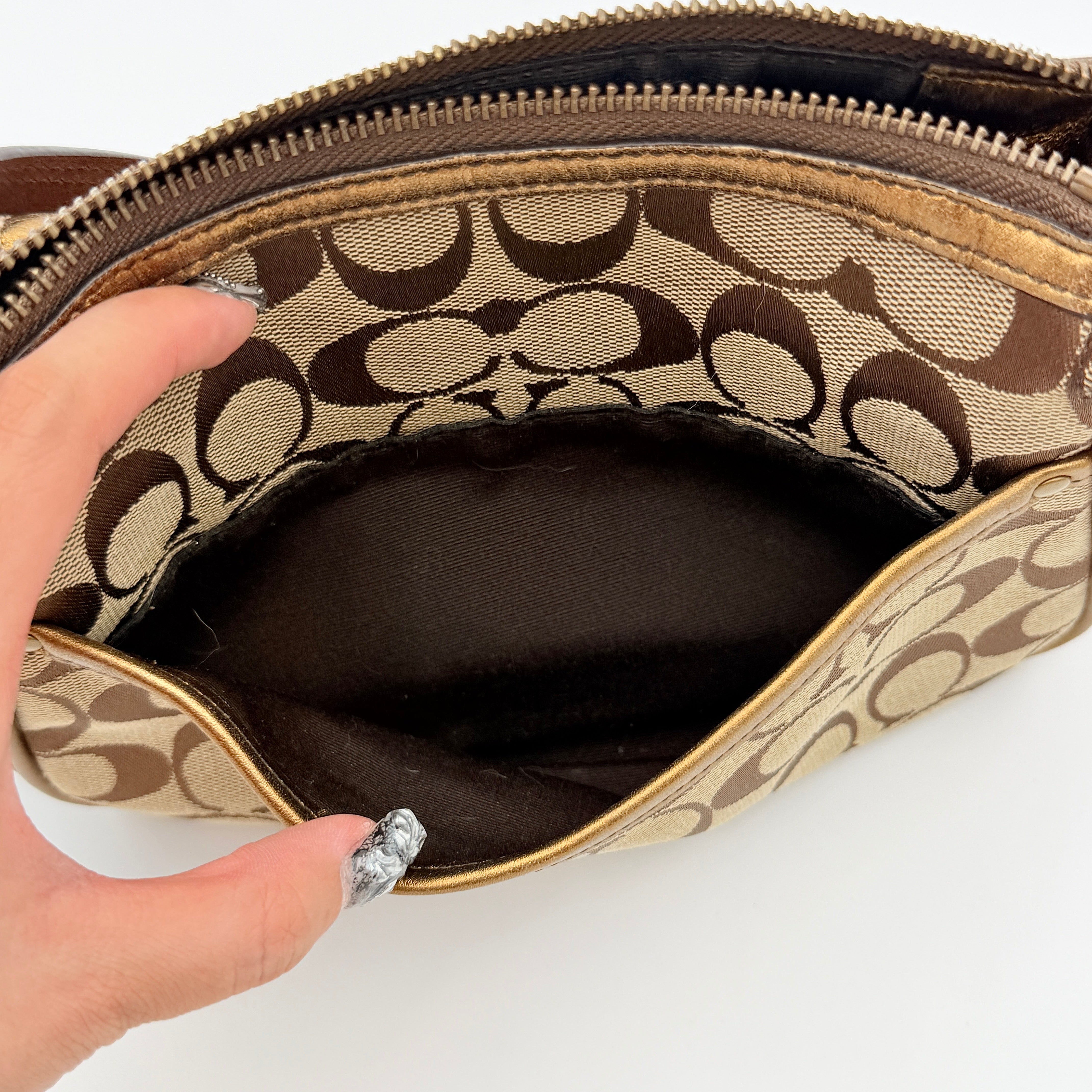 Coach Signature shoulder bag in beige jacquard with gold leather front flap, showcased on a plain background.