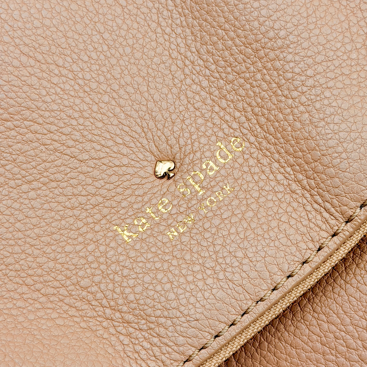 Kate Spade Cobble Hill Little Minka in beige pebbled leather with both top handle and detachable strap displayed.