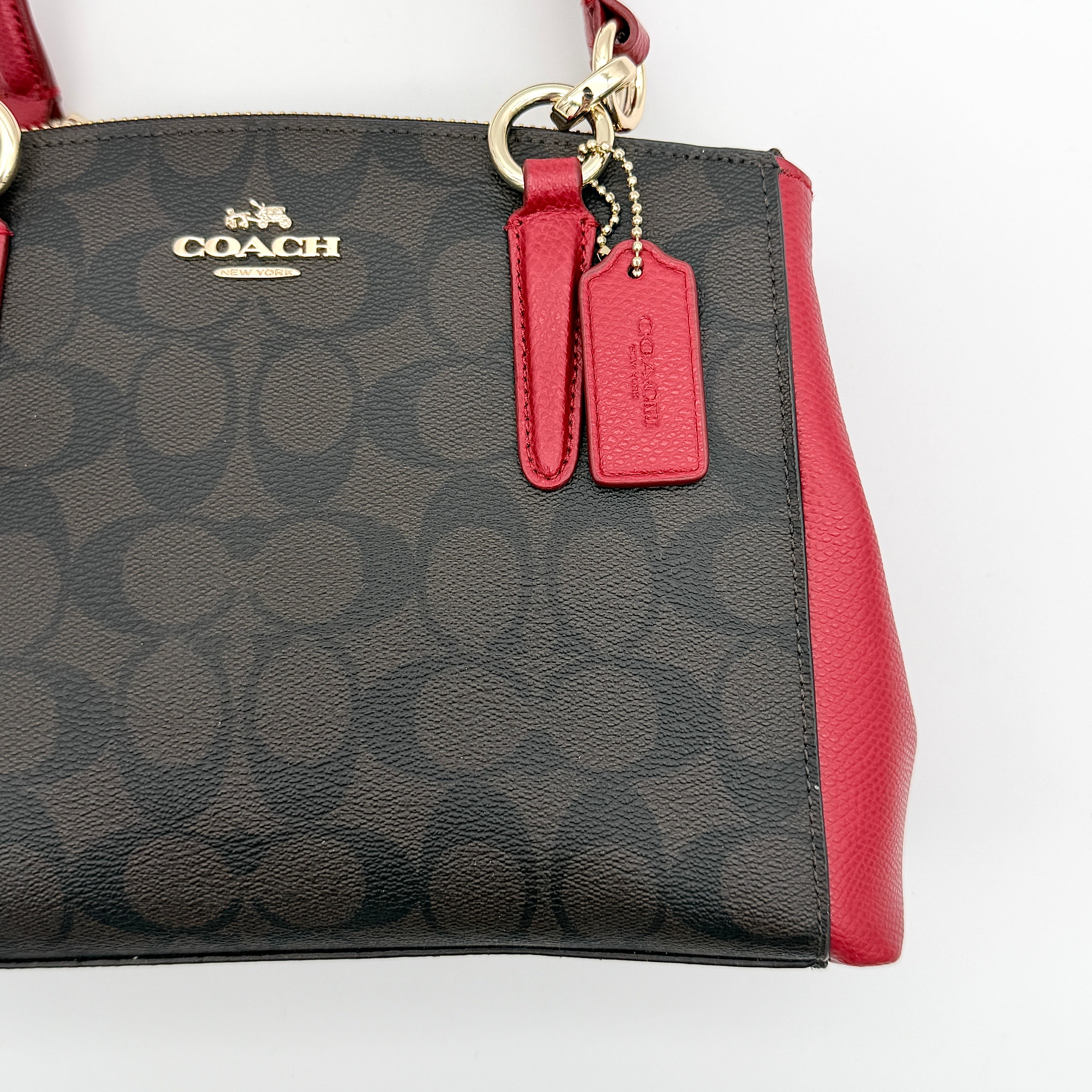 Coach 2Way Christie Carryall in brown coated canvas with red leather handles and sides, gold hardware, shown with detachable strap.