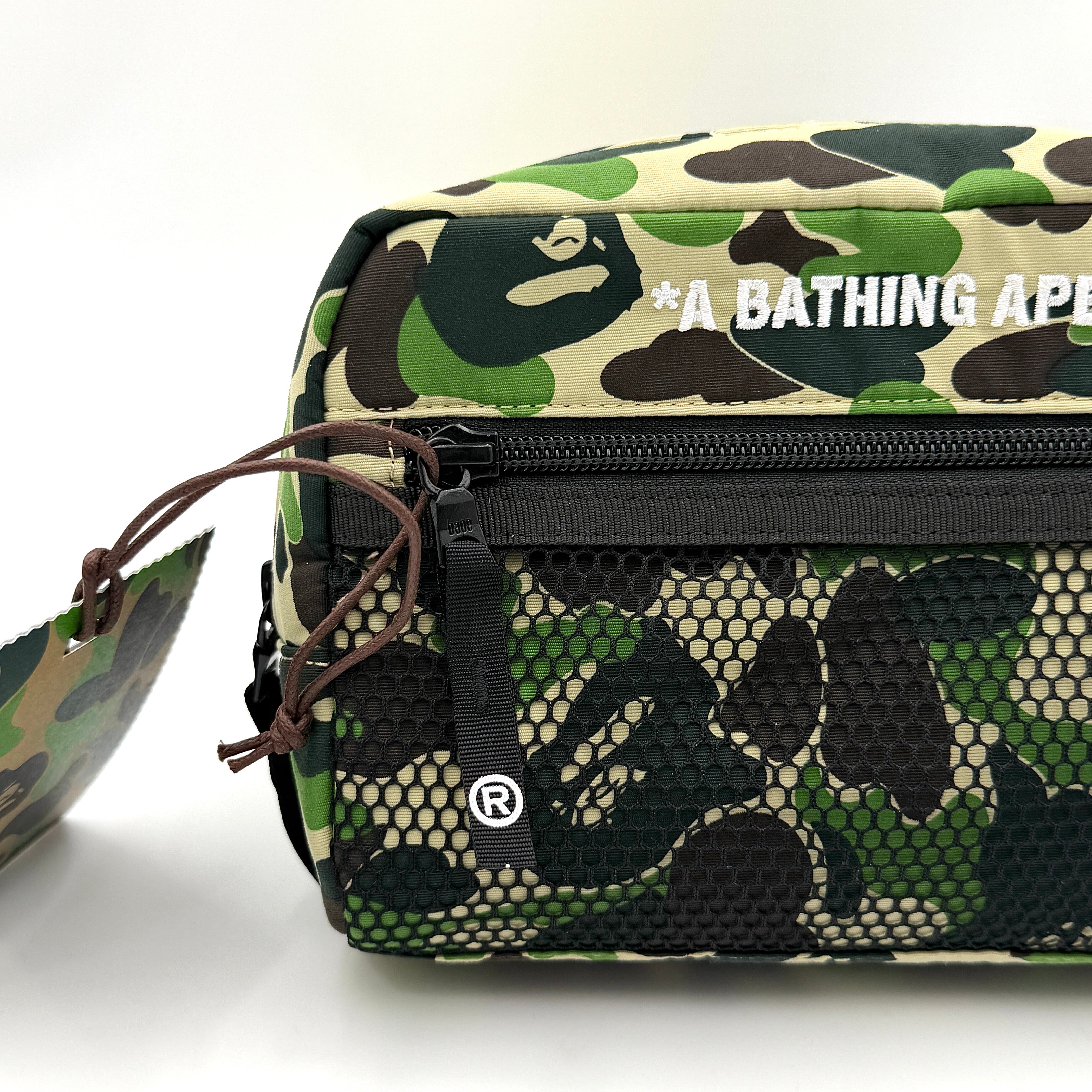 BAPE ABC Camo Pouch in green camouflage with mesh front pocket and embroidered A Bathing Ape logo.